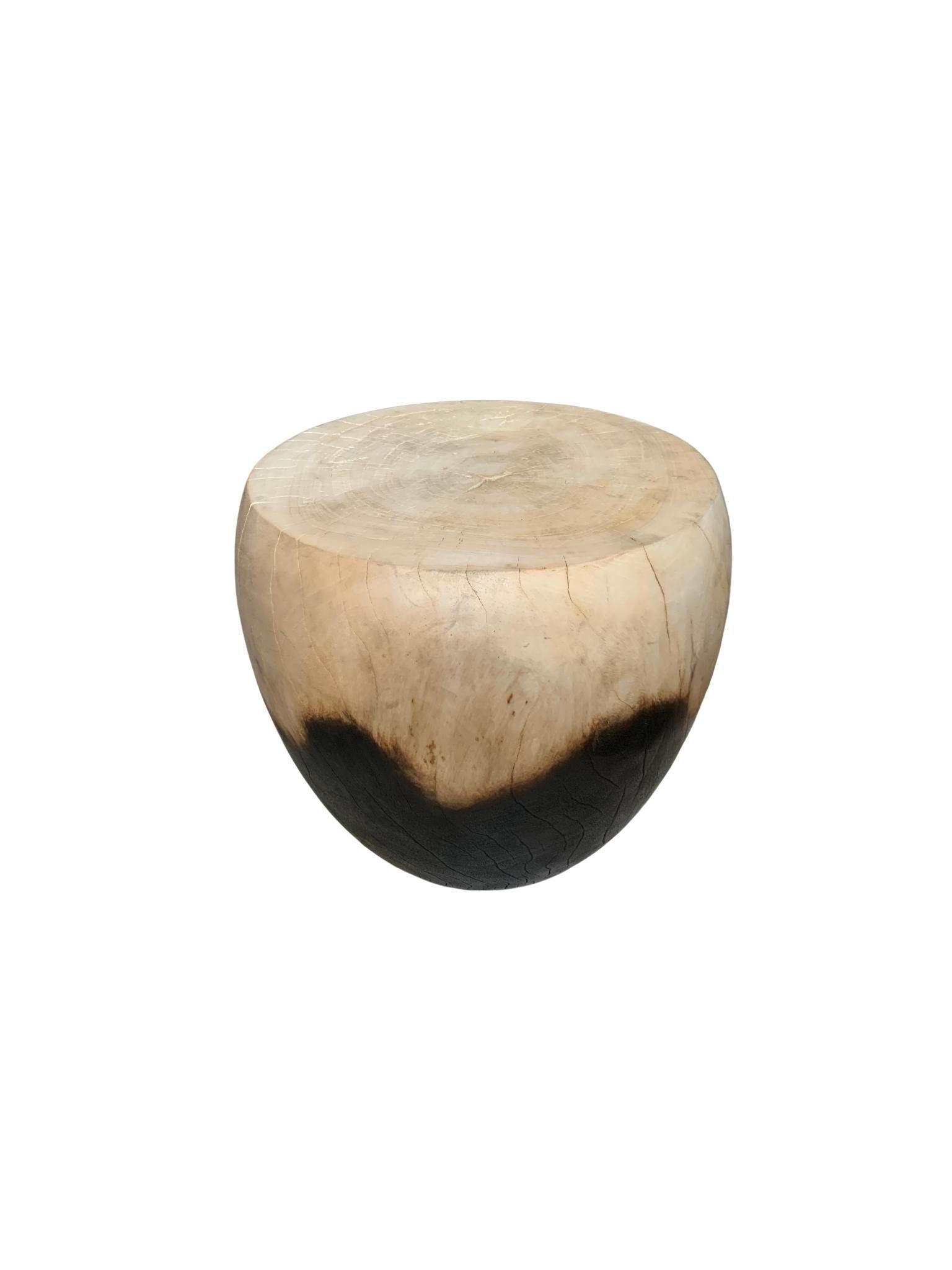 A wonderfully sculptural round side table. Its rich black pigment was achieved through burning the wood three times. Its contrast of cream/white and black was further achieved by bleaching the upper half of the table, creating a wonderful effect.