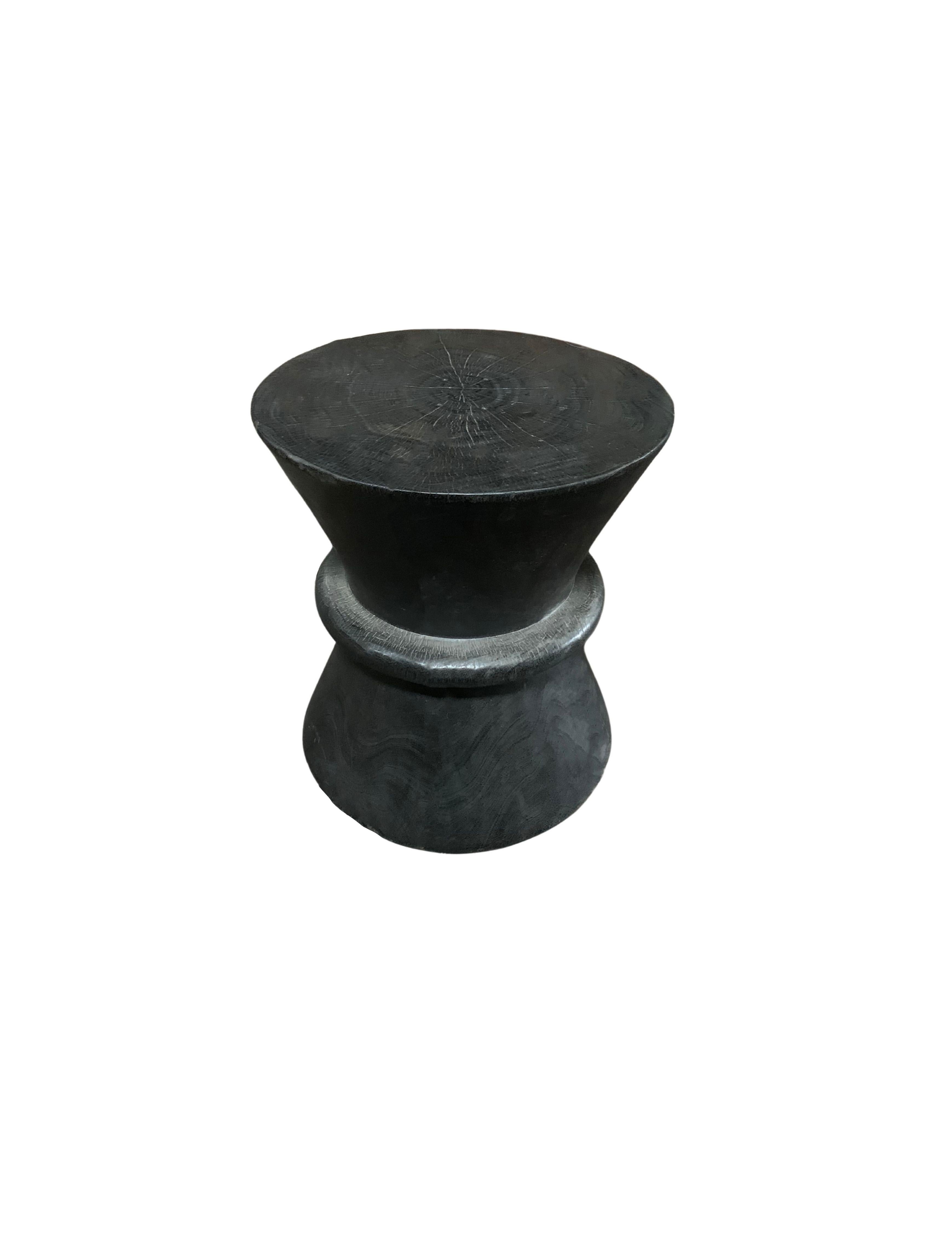 A wonderfully sculptural round side table. Its rich black pigment was achieved through burning the wood three times. Its neutral pigment and subtle wood texture makes it perfect for any space. A uniquely sculptural and versatile piece certain to
