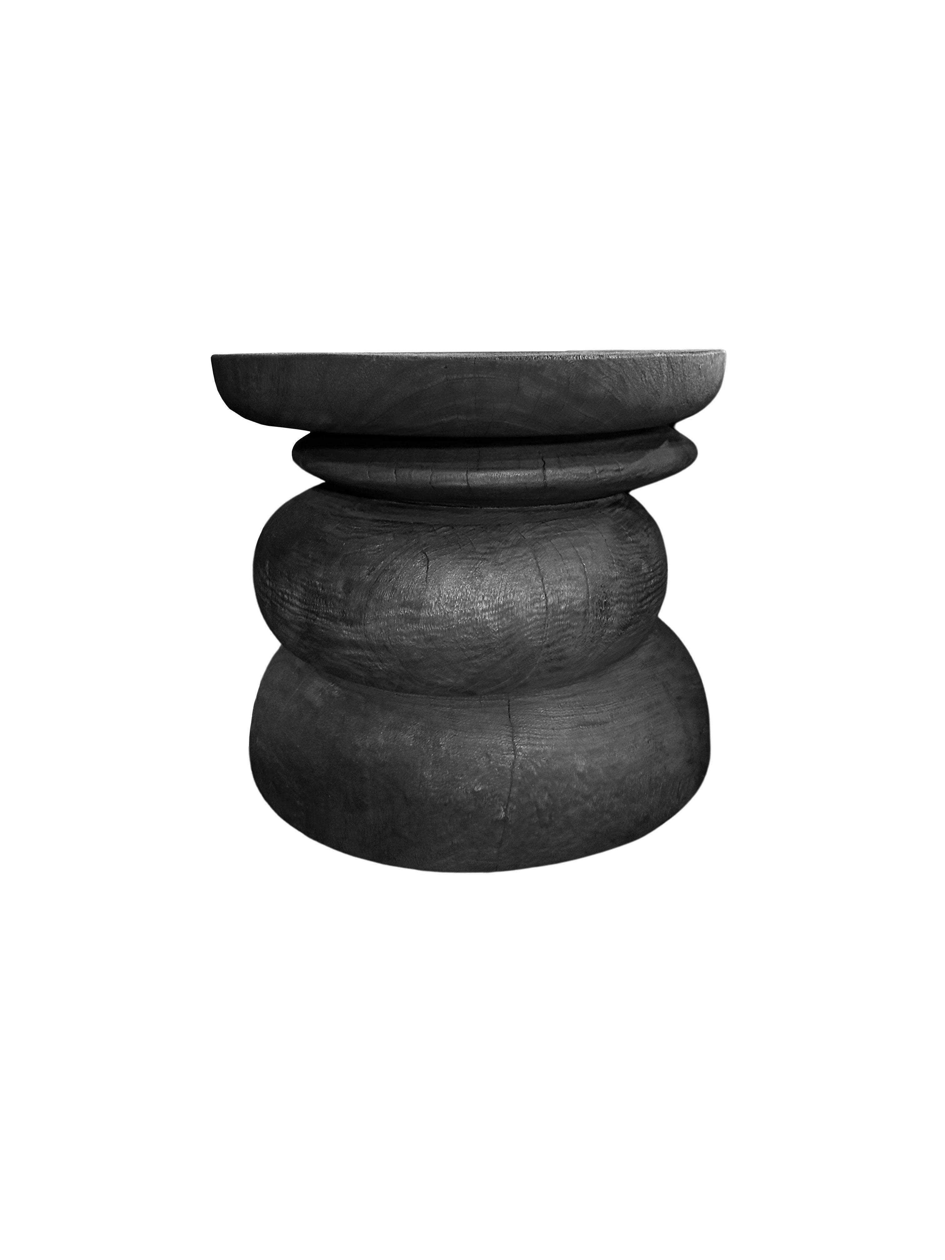 A wonderfully sculptural side table resembling a pile a river stones in a burnt finish. Its neutral pigment and subtle wood texture makes it perfect for any space. To achieve its black tone, the wood was burnt multiple times and then finished with a