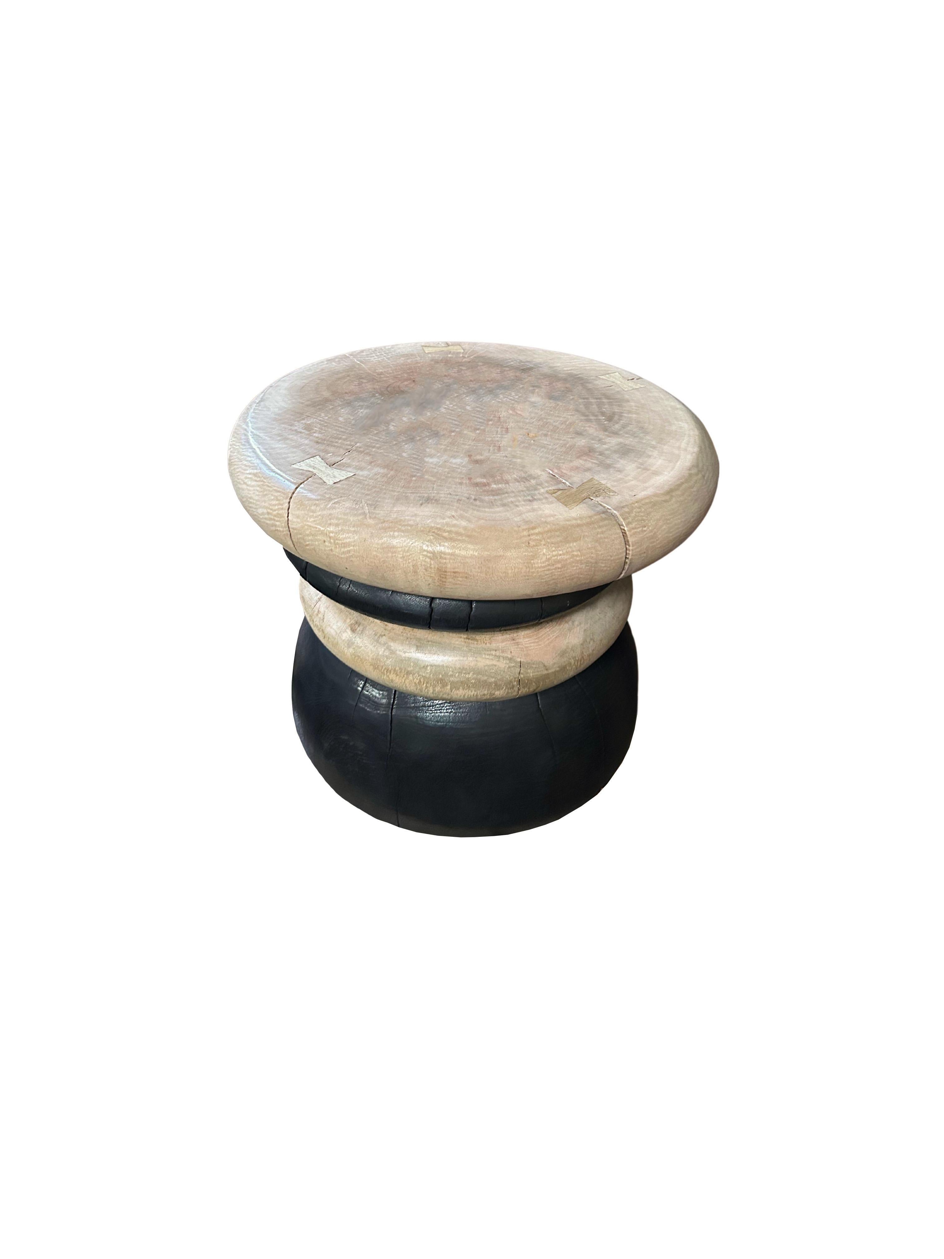 A wonderfully sculptural side table resembling a pile a river stones. Its black pigment features solid mango wood slabs that were burnt numerous times and then finished with a clear coat. The contrasting naturally toned slabs were meticulously