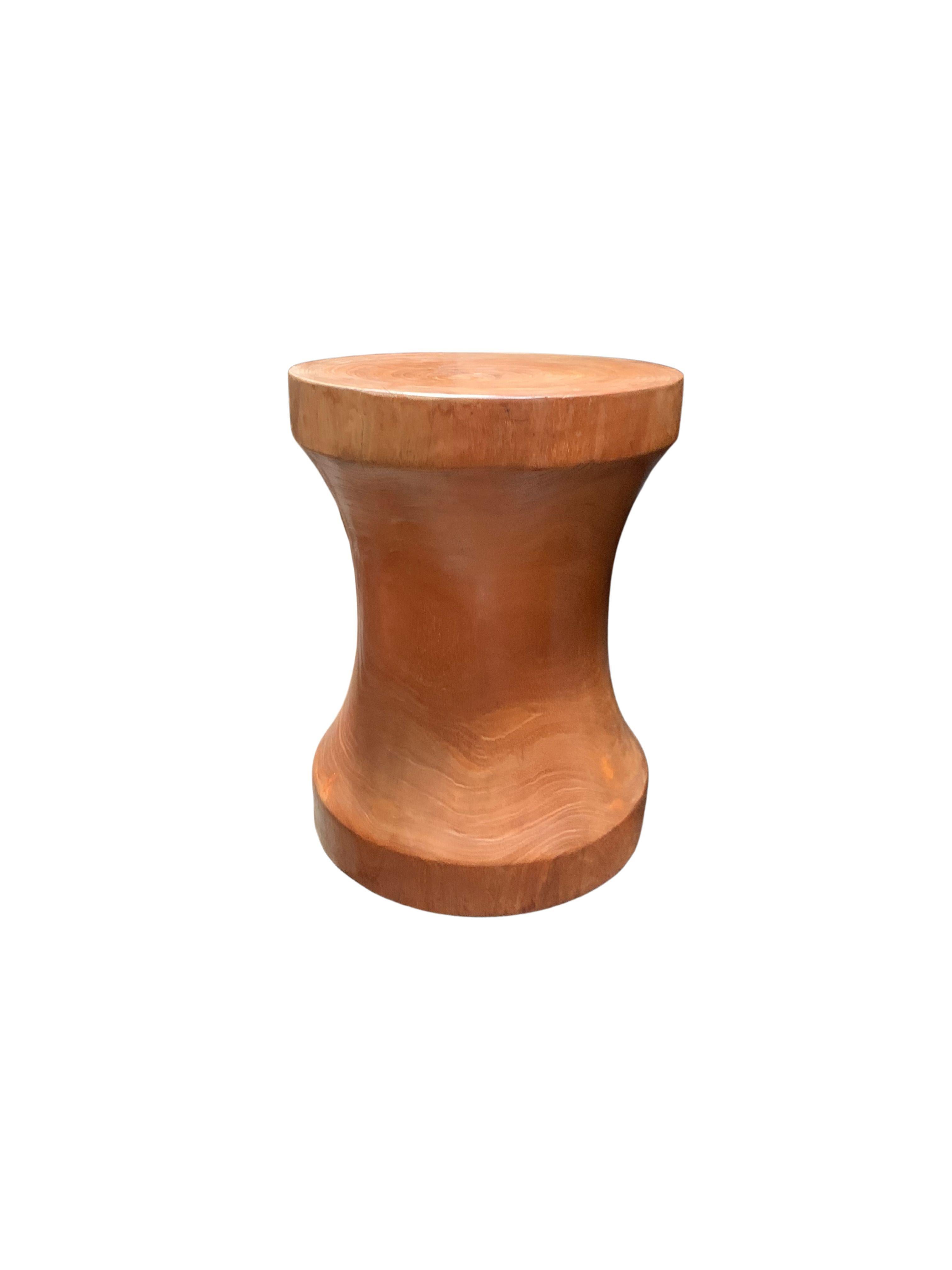 A wonderfully sculptural round side table with clear coated finish. Its neutral pigment and wood texture makes it perfect for any space. Carved from a solid trunk of mango wood, the wood textures are brought to life. A uniquely sculptural and