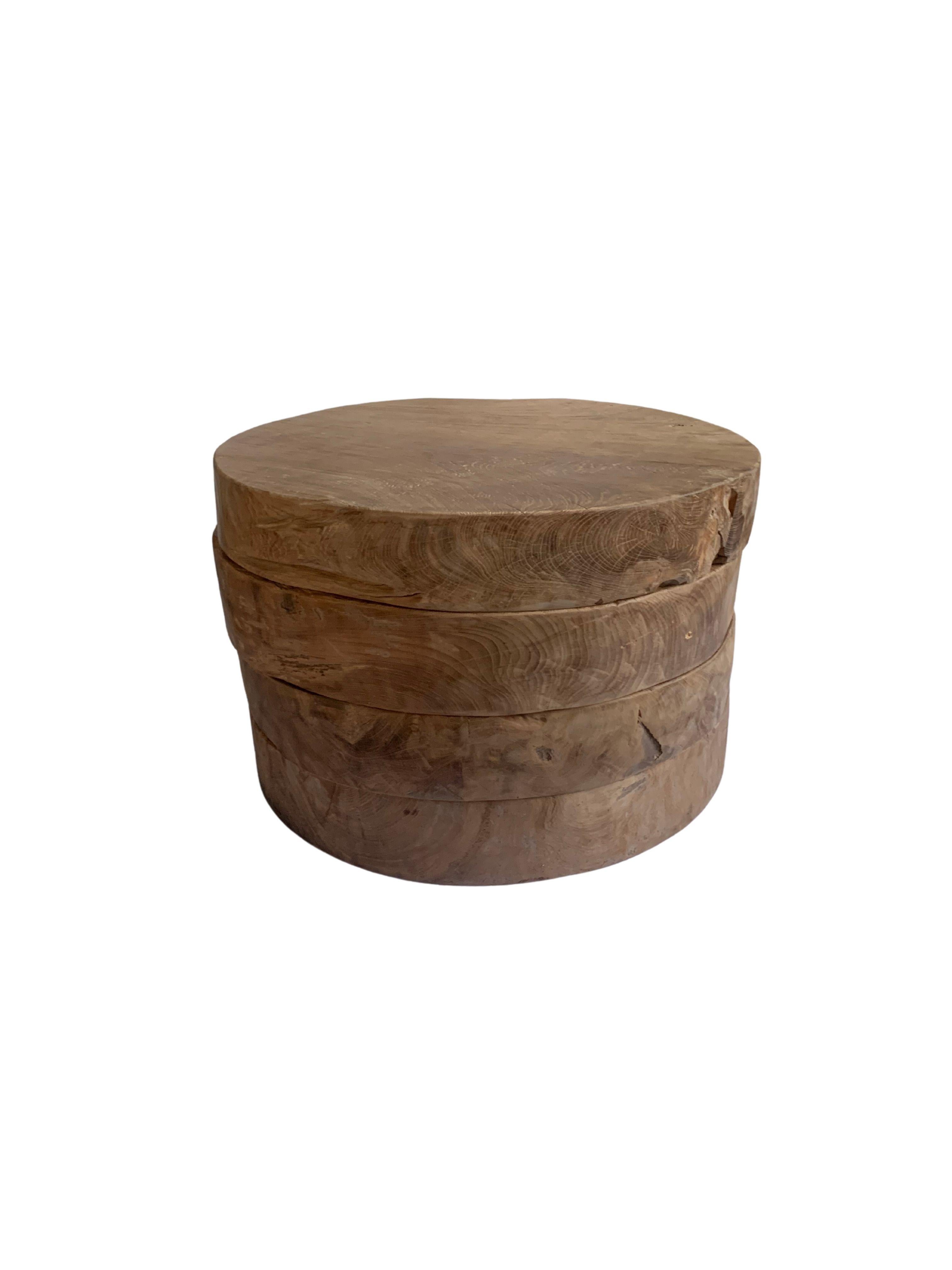 This side table is formed by four stacked round & solid teak wood slabs. A wonderfully sculptural round side table. Its neutral pigment and subtle wood texture makes it perfect for any space. Each slab is solid and heavy allowing for the table to