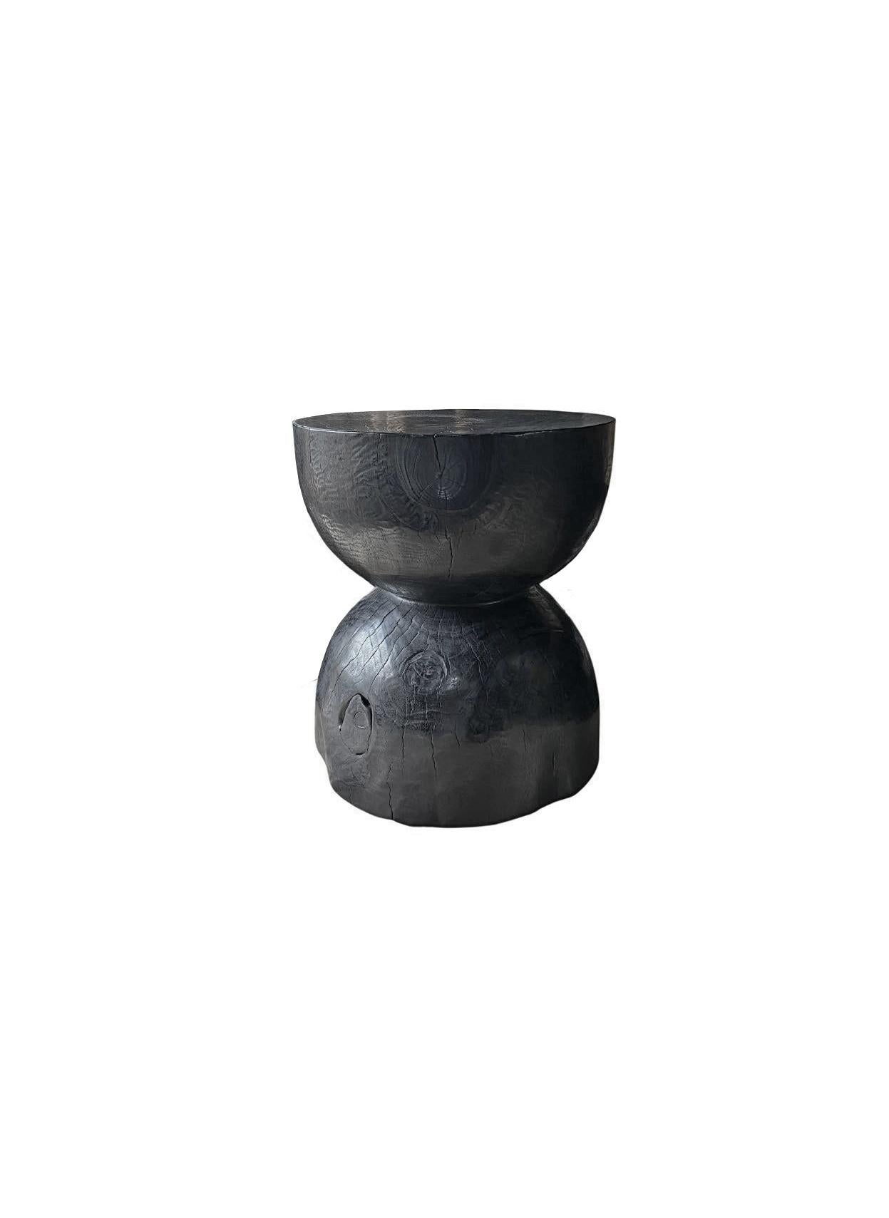 A wonderfully sculptural side table. Its rich black pigment was achieved through burning the wood three times. Its neutral pigment and subtle wood texture makes it perfect for any space. A uniquely sculptural and versatile piece certain to invoke