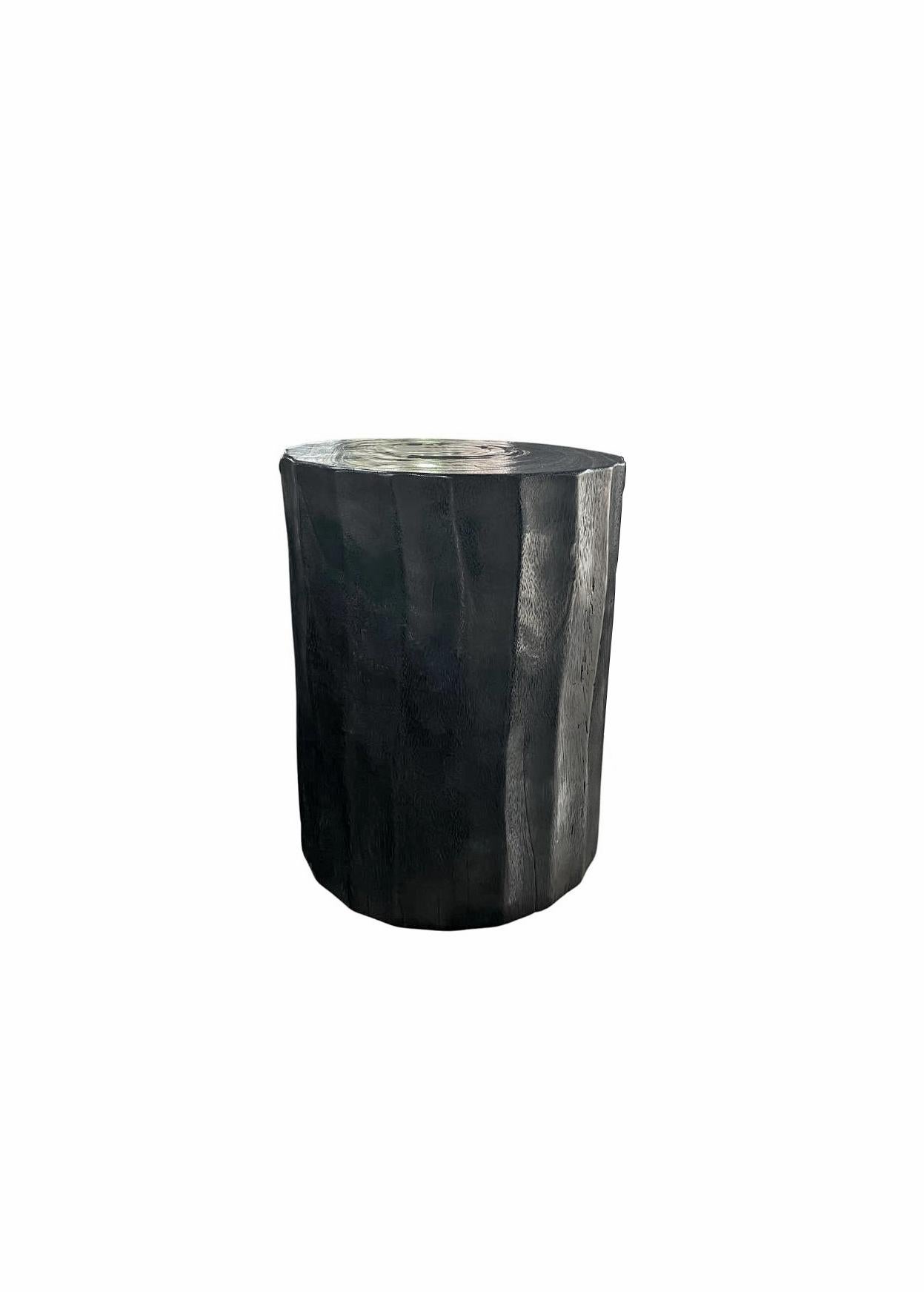 A wonderfully sculptural side table. Its rich black pigment was achieved through burning the wood three times. Its neutral pigment and subtle wood texture makes it perfect for any space. A uniquely sculptural and versatile piece certain to invoke