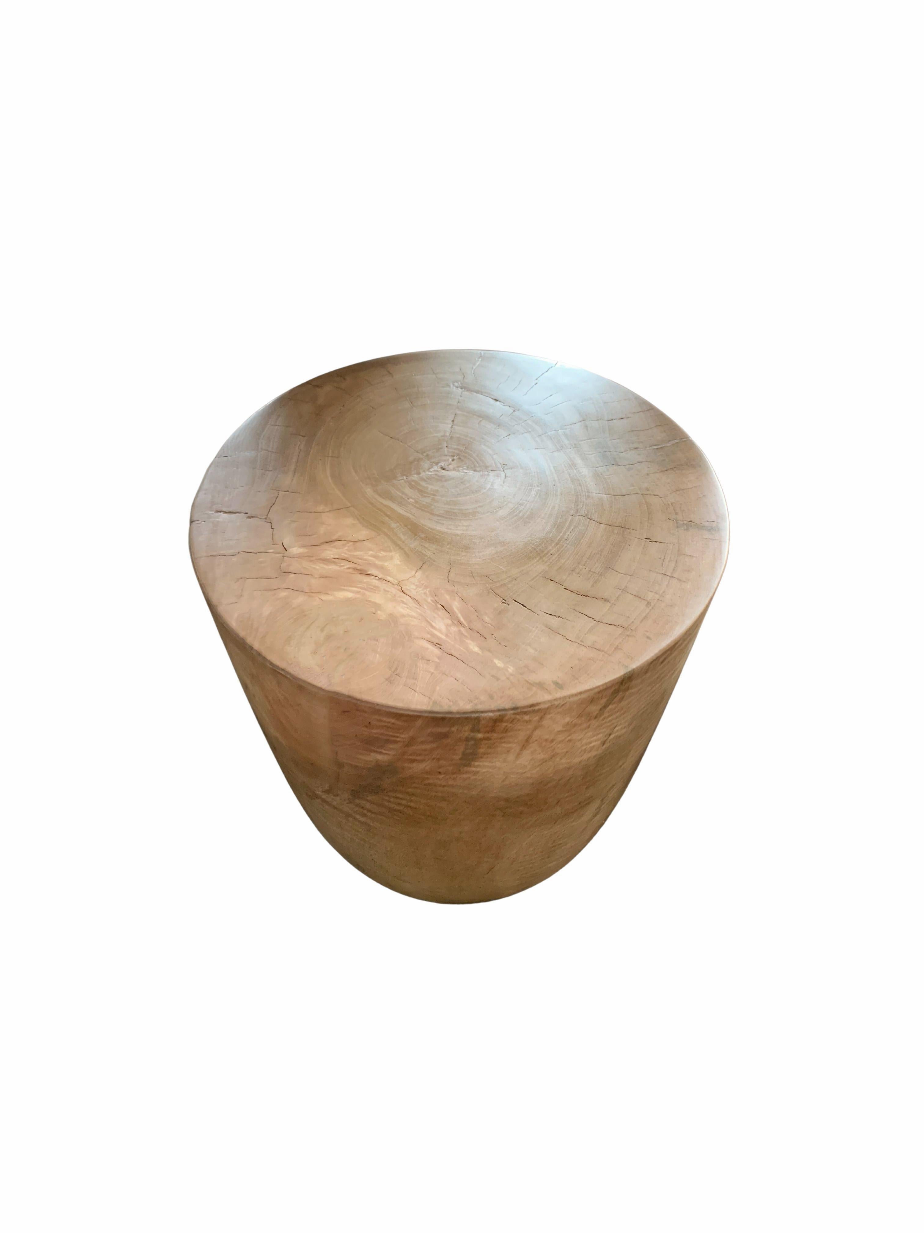 A wonderfully sculptural round side table. Its neutral pigment and subtle wood texture makes it perfect for any space. A uniquely sculptural and versatile piece certain to invoke conversation. This table was crafted from solid mango wood and has a