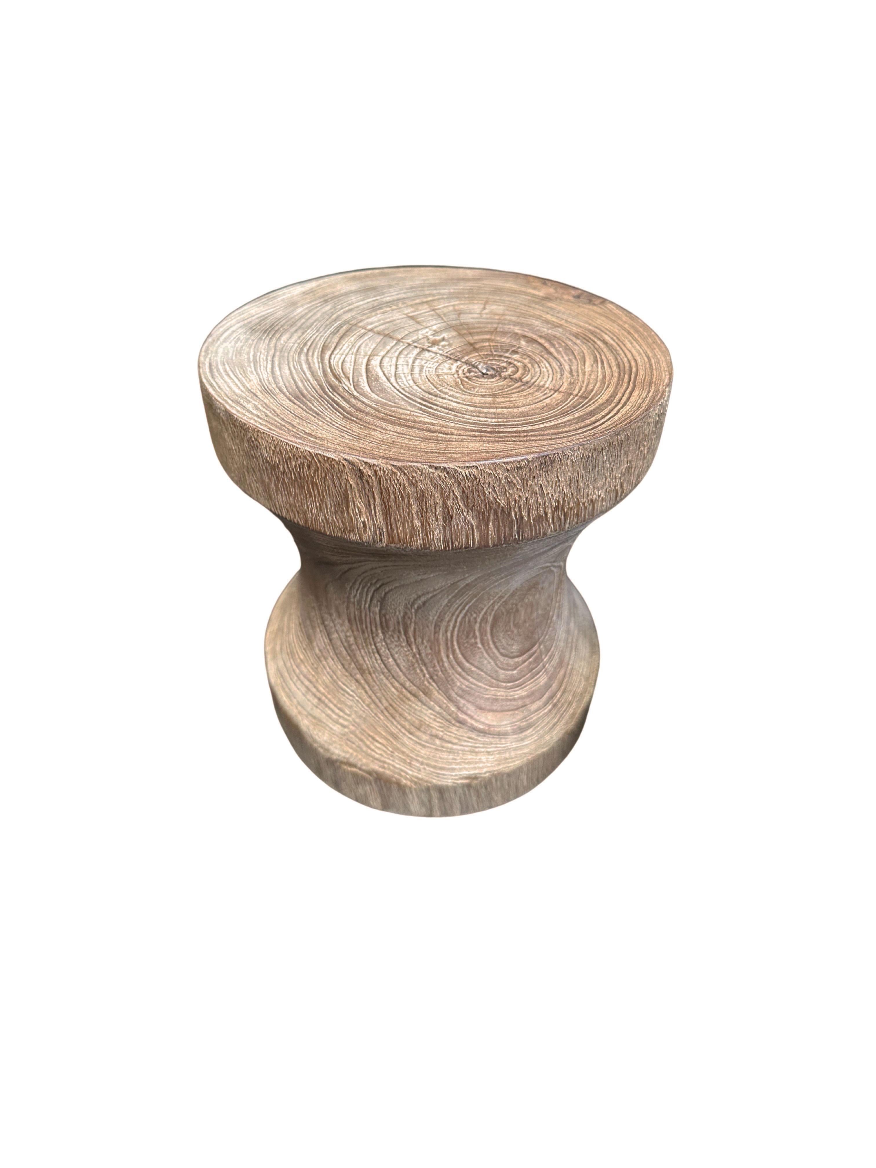 A wonderfully sculptural round side table in a natural finish. Its neutral pigment and wood texture makes it perfect for any space. Carved from a solid trunk of teak, the wood textures are brought to life. 

 