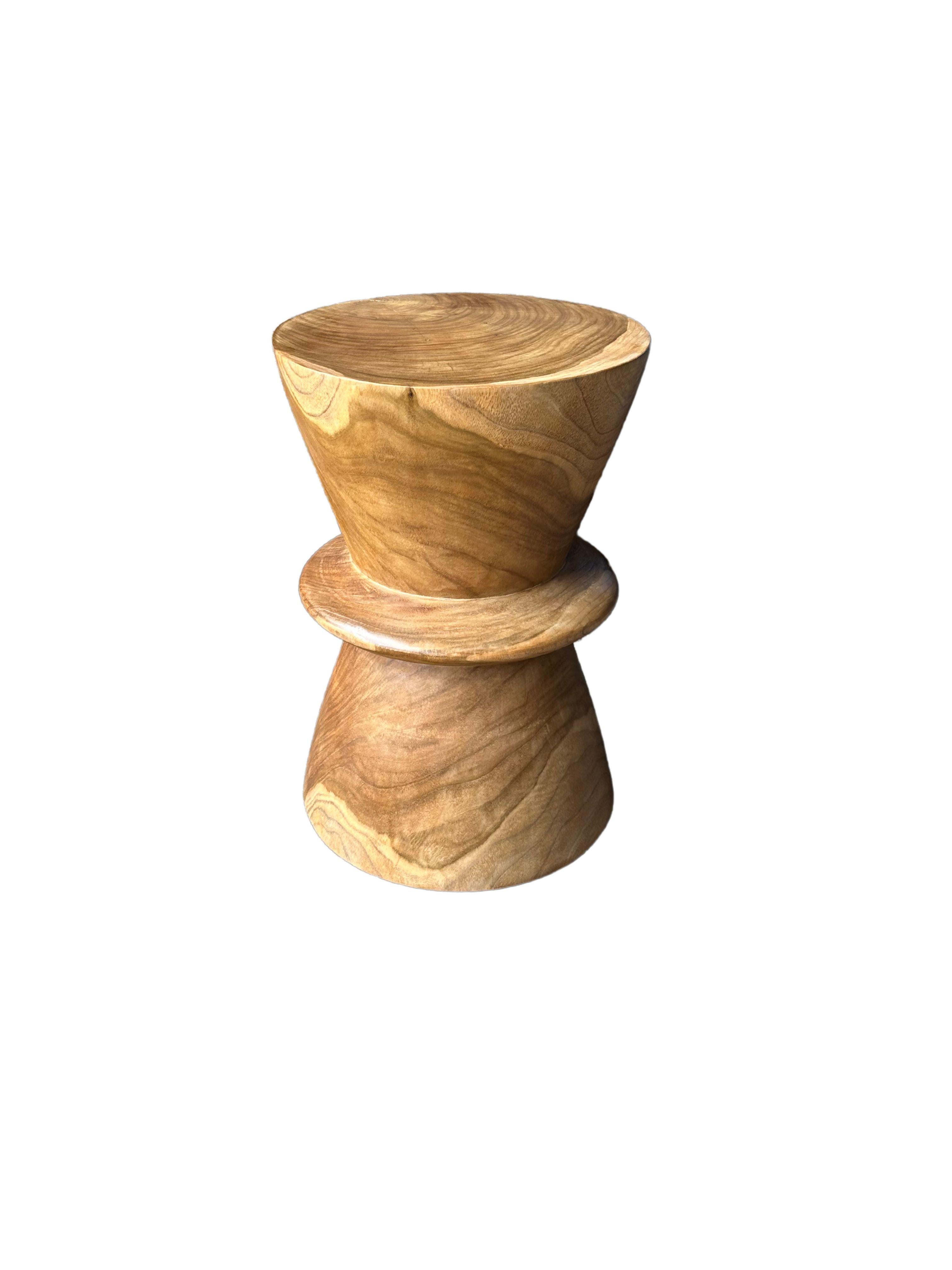 Una mesa auxiliar redonda maravillosamente escultural en acabado natural. Su pigmento neutro y su textura de madera lo hacen perfecto para cualquier espacio. Talladas en un tronco macizo de teca, las texturas de la madera cobran vida. 

 