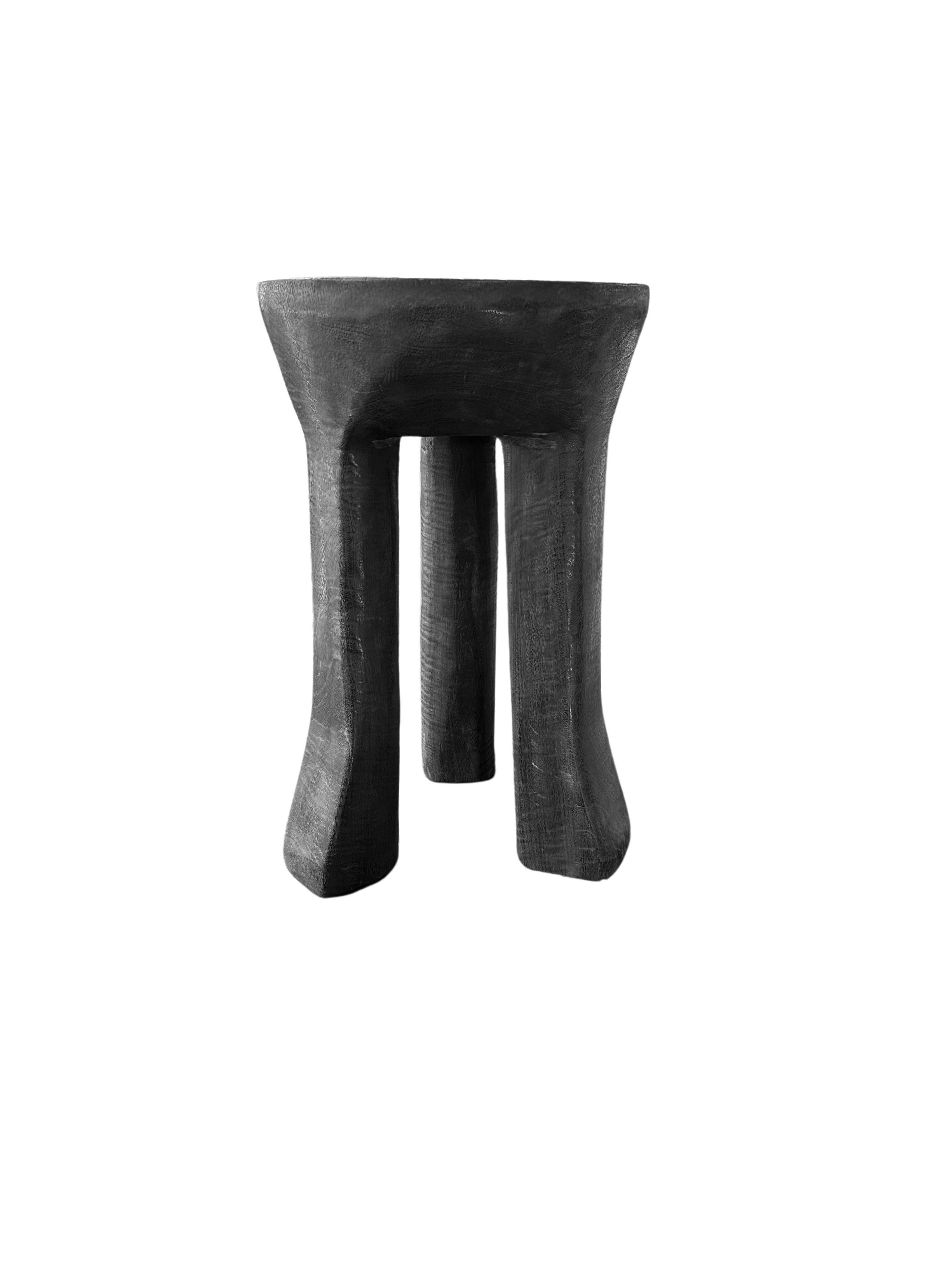 Une table d'appoint ronde merveilleusement proportionnée, dotée de pieds élégamment incurvés. Fabriquée en bois de manguier massif, cette table a une finition brûlée. Pour obtenir son pigment, le bois a été brûlé plusieurs fois et terminé par une