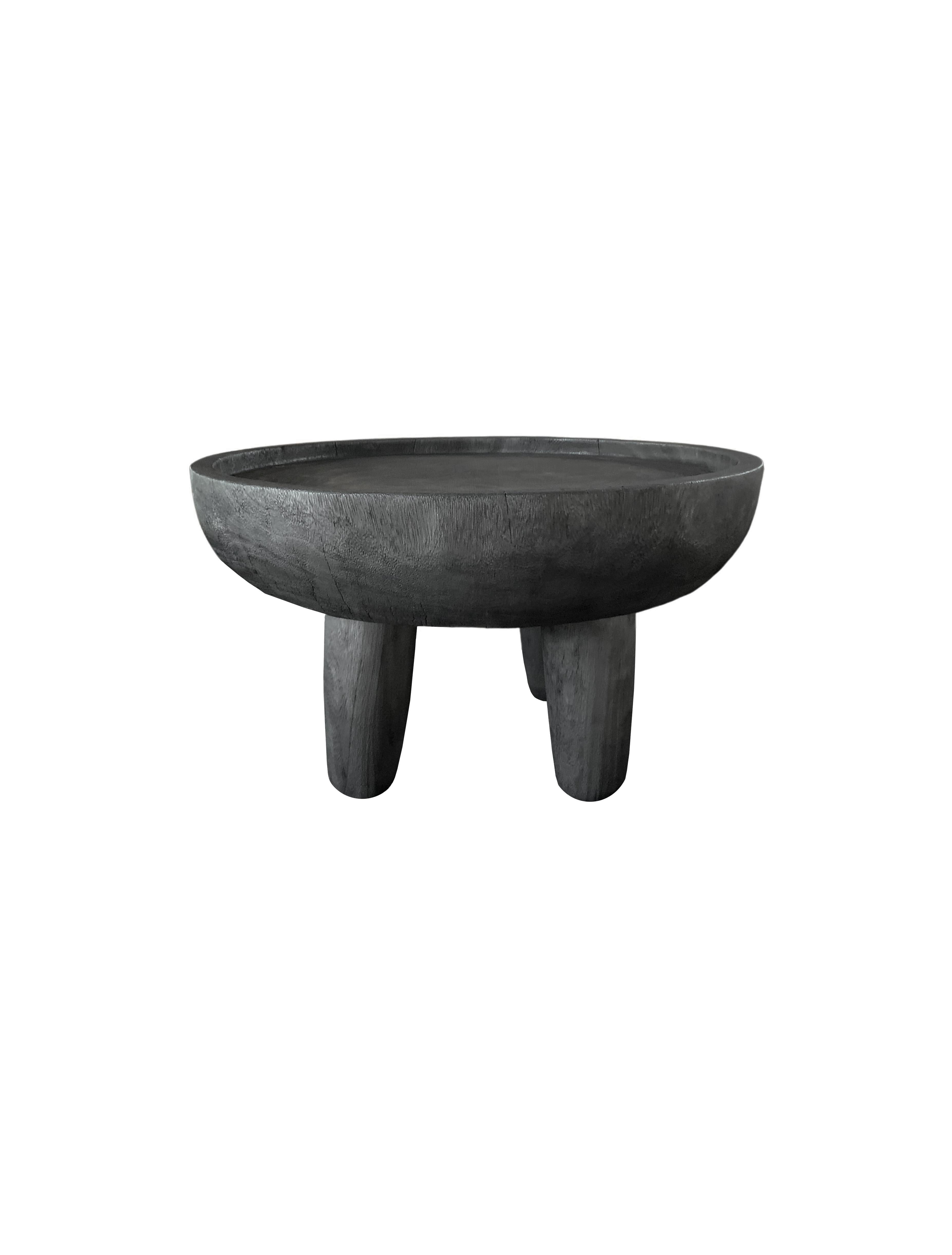 A wonderfully sculptural round side table. Its rich black pigment was achieved through burning the wood three times. Its neutral pigment and subtle wood texture makes it perfect for any space. A uniquely sculptural and versatile piece. This table