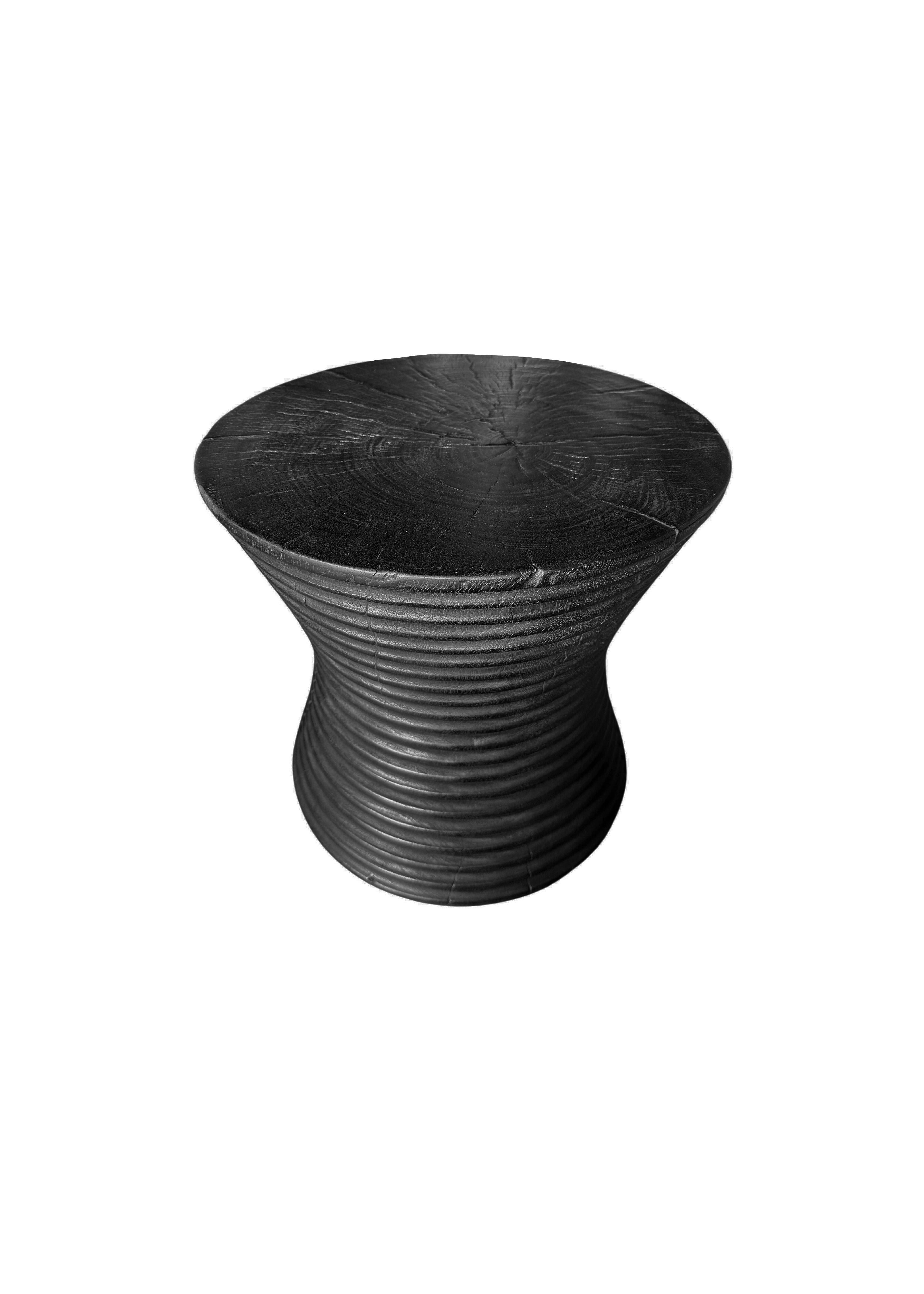 Una mesa auxiliar redonda maravillosamente escultural. Su pigmentación y textura se consiguieron lijando meticulosamente la mesa, quemando la madera varias veces y acabando con una capa transparente. Una pieza única, escultural y versátil. Los