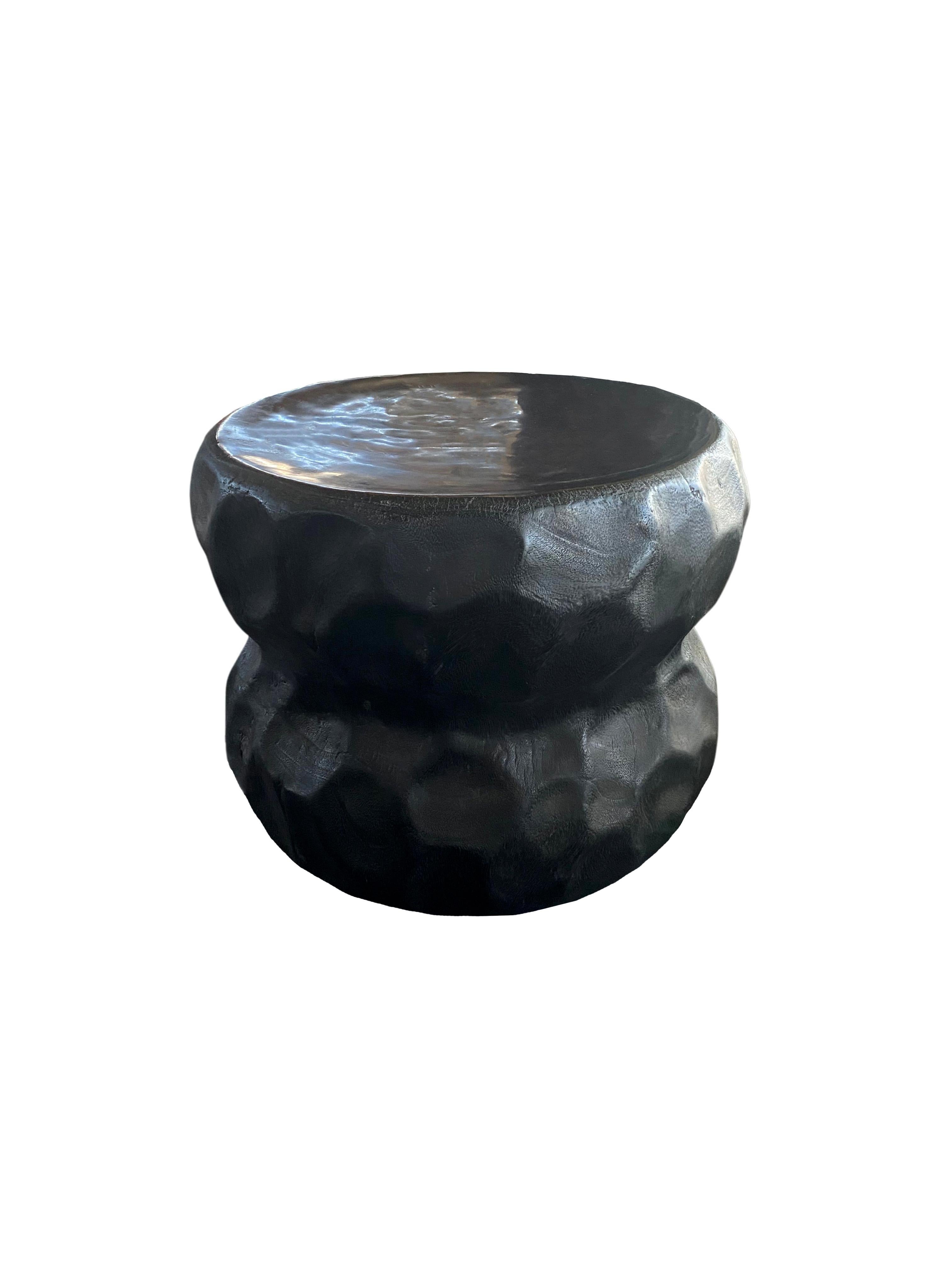 A wonderfully sculptural round side table with a hand-hewn design on its exterior. Its neutral pigment and subtle wood texture makes it perfect for any space. A uniquely sculptural and versatile piece certain to invoke conversation. This table was