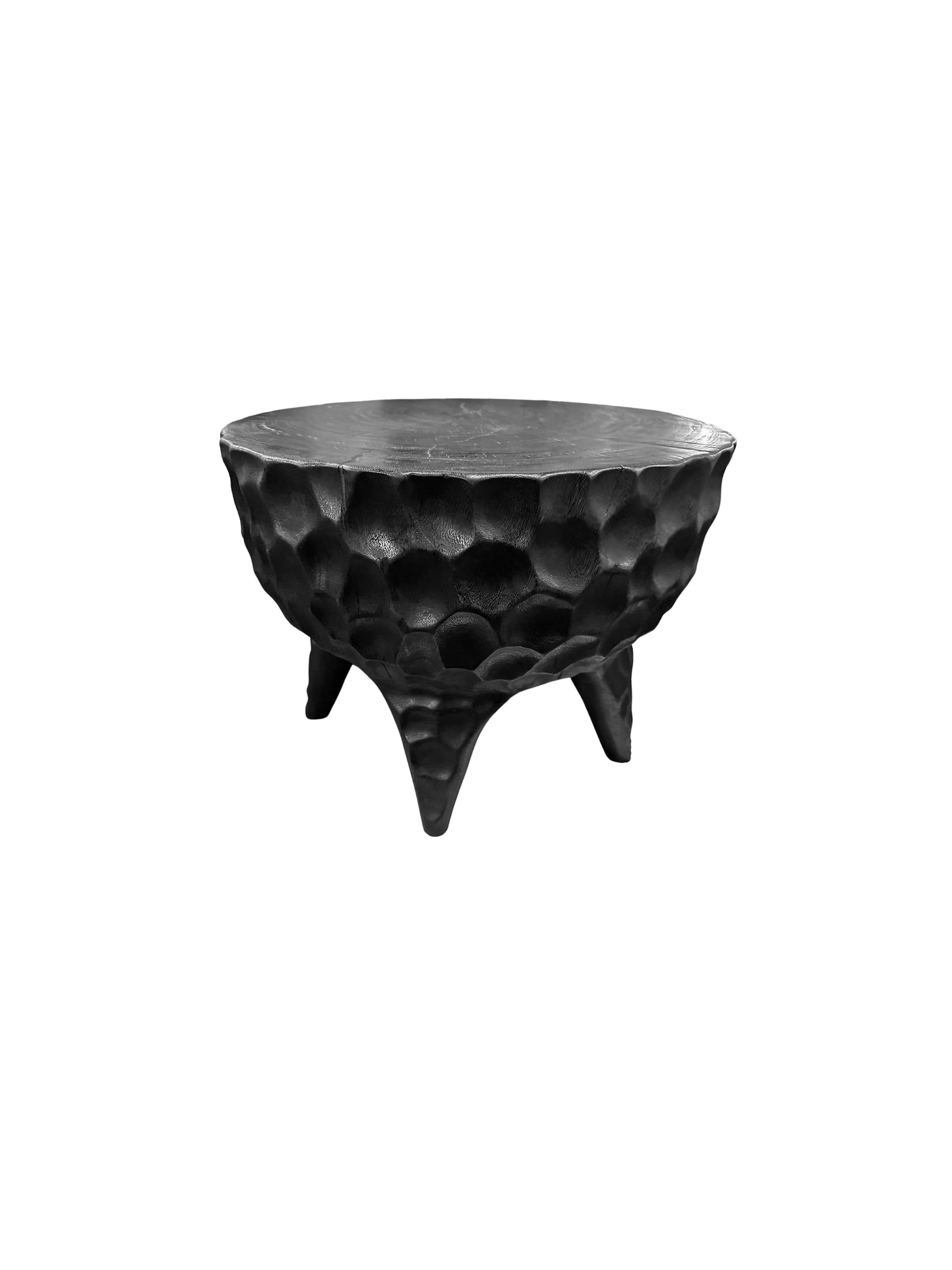 An elegantly rounded, sculptural side table crafted from a single block of mango wood. Unique to this table is the hand-hewn detailing on all sides. The table top was sanded down providing a smooth finish and contrast in texture. To achieve its