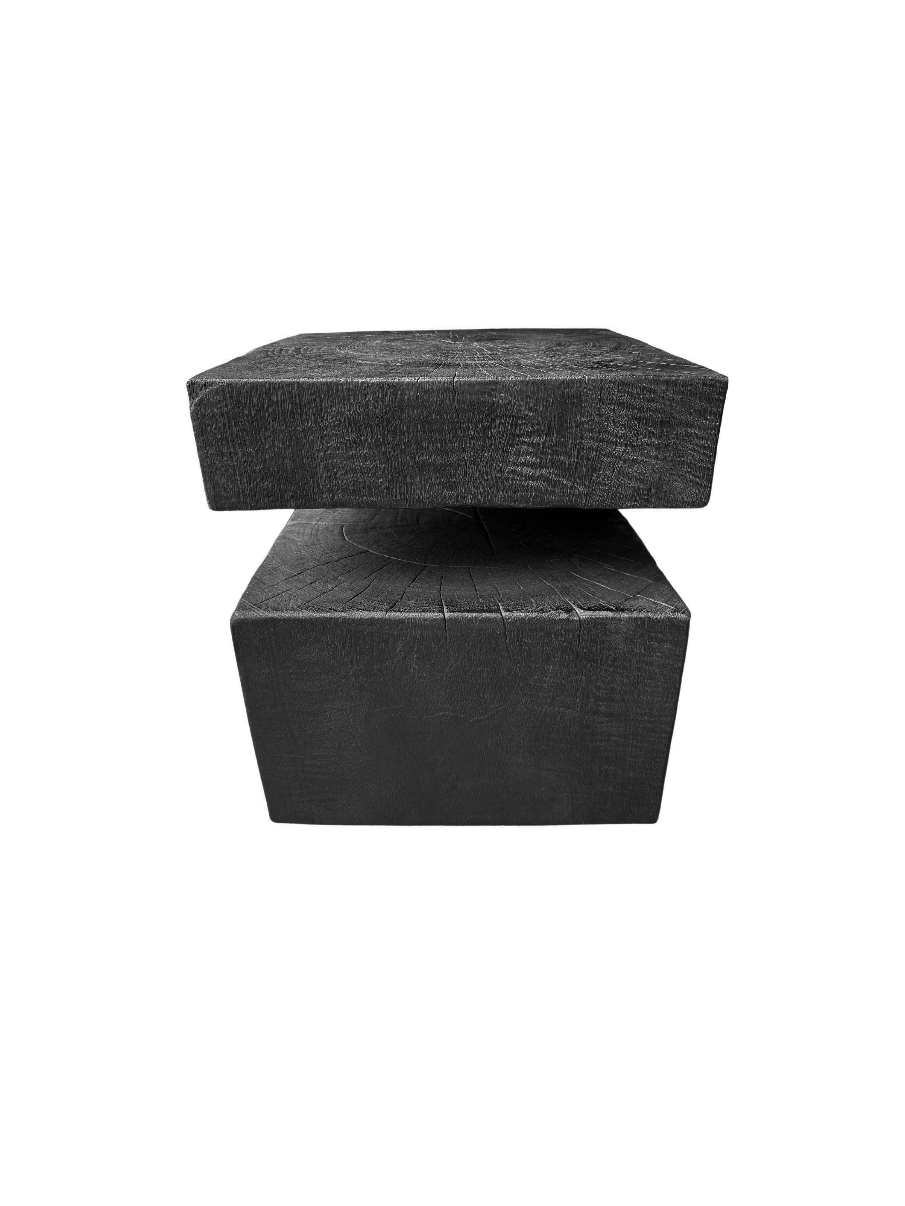 A wonderfully sculptural side table. Its neutral pigment makes it perfect for any space. It was crafted from a solid block of mango wood. To achieve its dark black color the wood was burnt several three times and then coated with clear finish. The