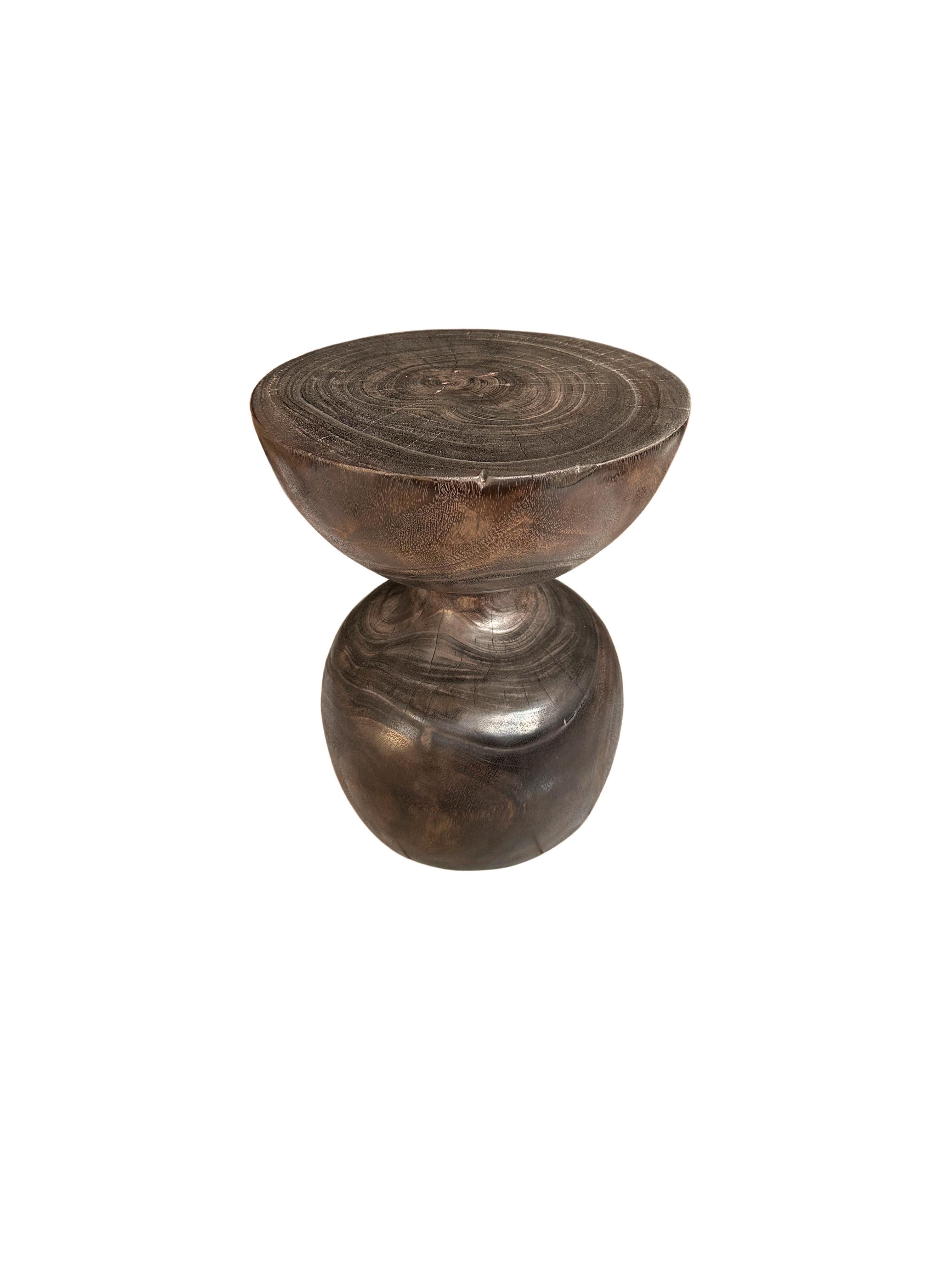 A wonderfully sculptural round side table. Its pigment and texture was achieved through an Espresso finish, named for its resemblance to coffee where the wood was burnt several times and finished with a clear coat. A uniquely sculptural and
