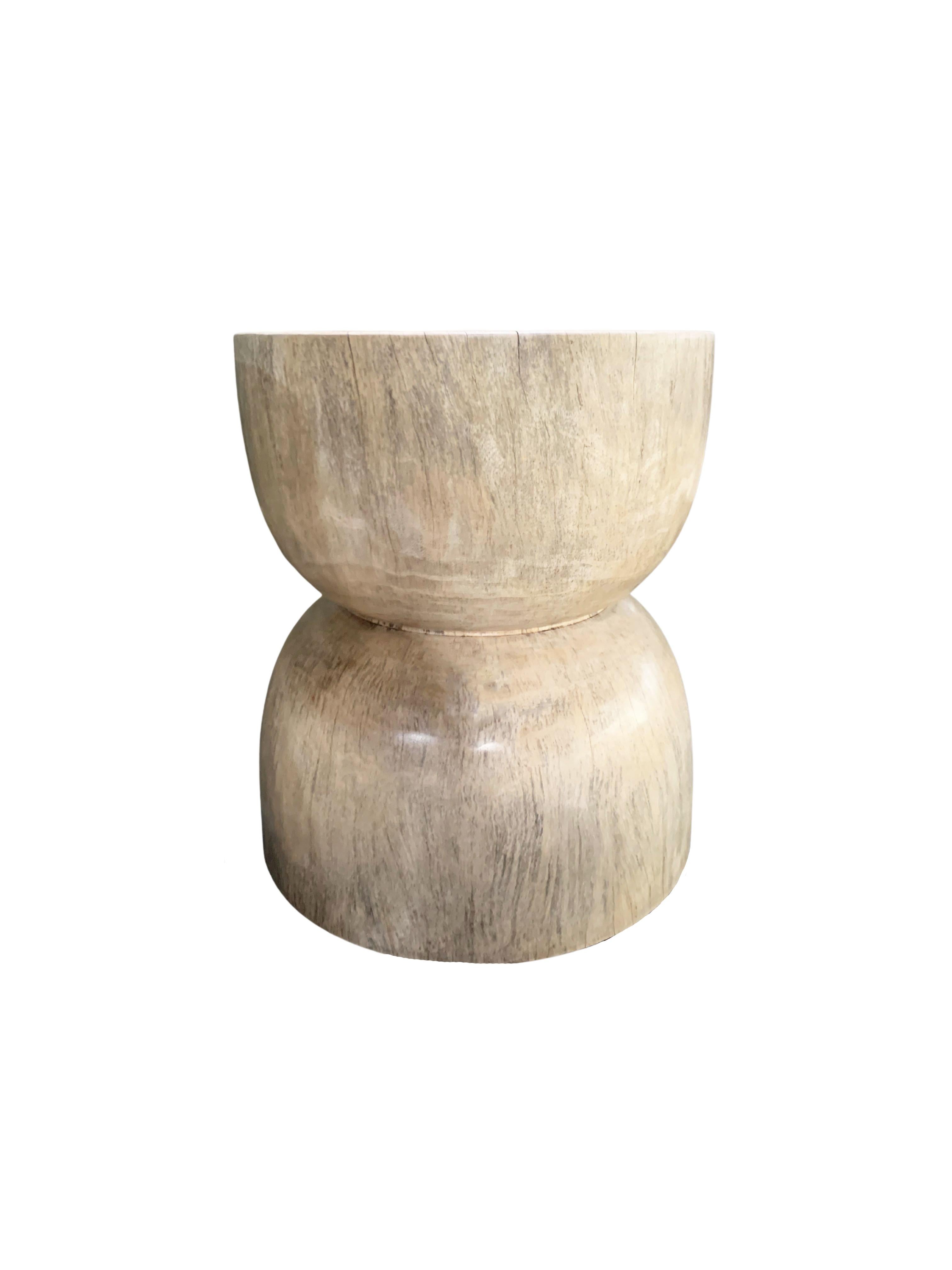 A wonderfully sculptural round side table or stool. Its neutral pigment makes it perfect for any space. A uniquely sculptural and versatile piece certain to invoke conversation. It was crafted from a solid block of tamarind wood and has a smooth