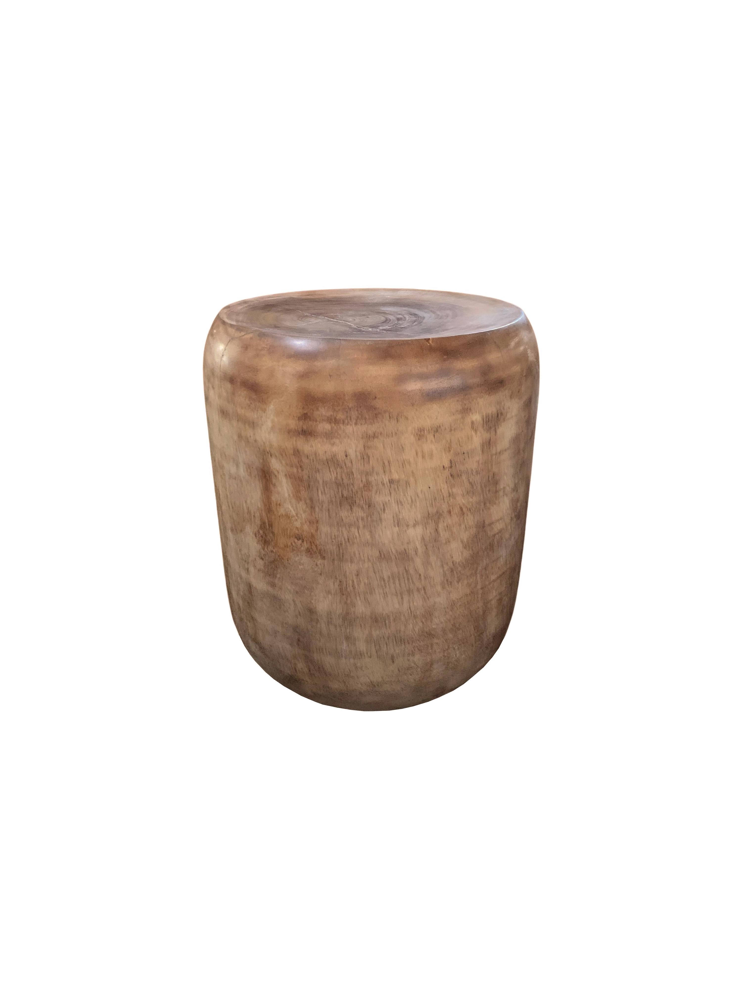 A wonderfully sculptural round side table or stool. Its neutral pigment makes it perfect for any space. A uniquely sculptural and versatile piece certain to invoke conversation. It was crafted from a solid block of mango wood and has a smooth