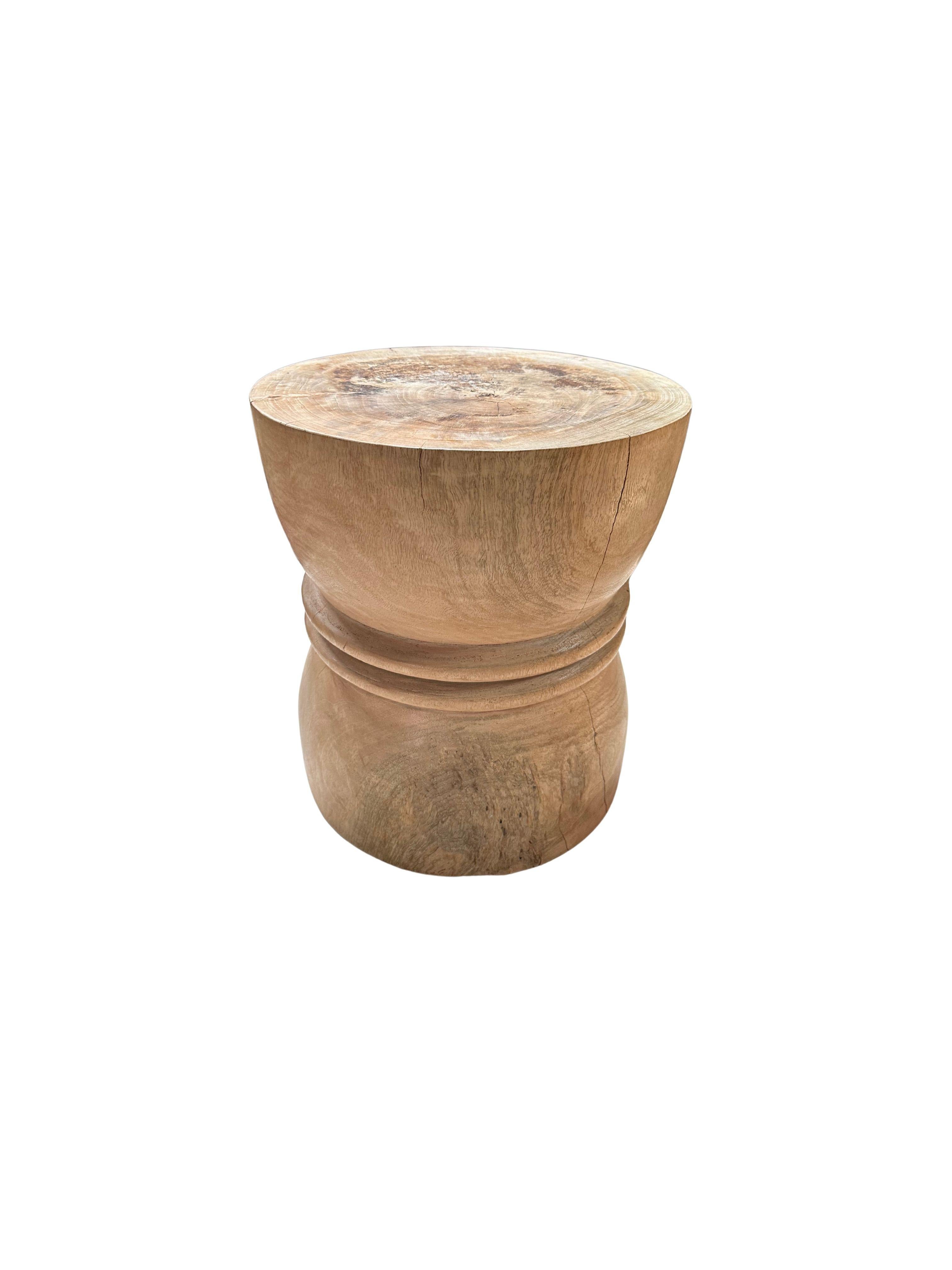 A wonderfully sculptural round side table or stool. Its neutral pigment makes it perfect for any space. A uniquely sculptural and versatile piece certain to invoke conversation. It was crafted from a solid block of mango wood and has a smooth