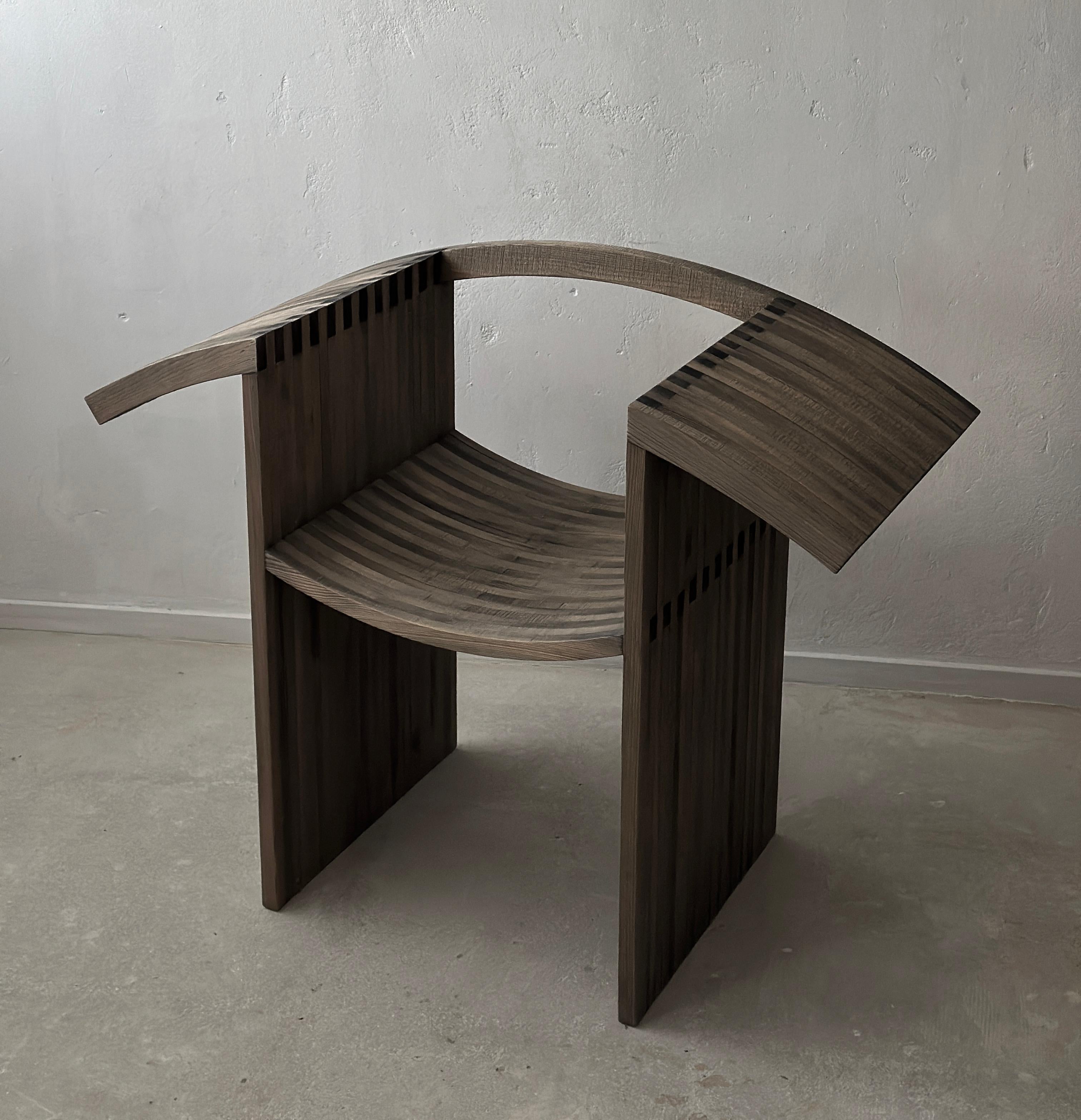 Voici une chaise exclusive qui redéfinit l'élégance et le savoir-faire. Cette pièce unique allie harmonieusement le minimalisme moderne et le travail artisanal du bois, créant ainsi une forme architecturale audacieuse, à la fois saisissante et
