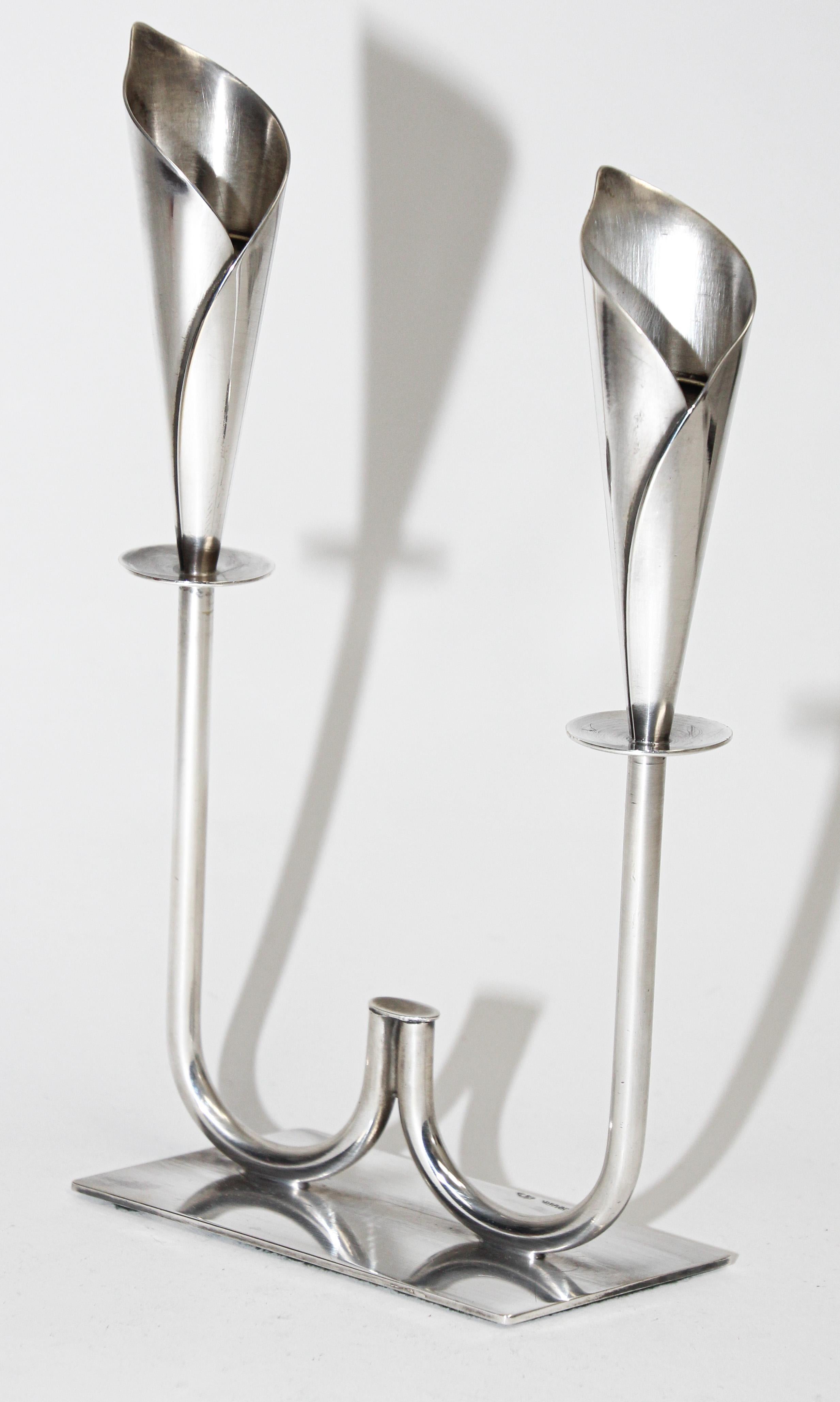 Hans Jensen Calla Lily candle holders in silver plate. 
by Hans Jensen, marked “Denmark” along with the maker’s mark. 
Vintage Mid-Century Danish Modern Hans Jensen silver plated sculptural Calla Lily candleholder featuring two candle cups, in a