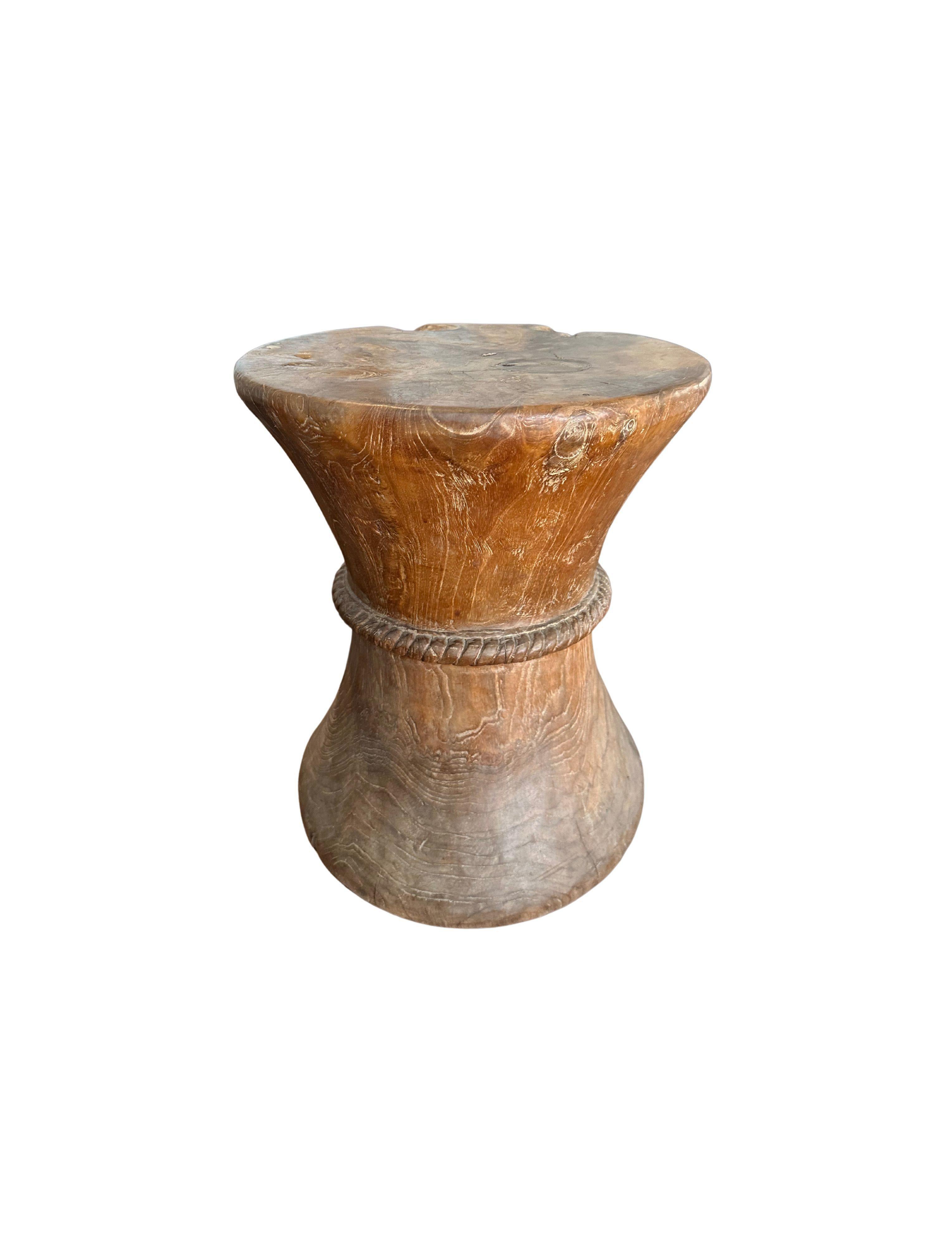 A wonderfully sculptural solid teak side table with carved detailing at its center. The mix of wood textures and shades add to its charm.

This is a made to order item and the images provided in this listing are a sample image of the finished