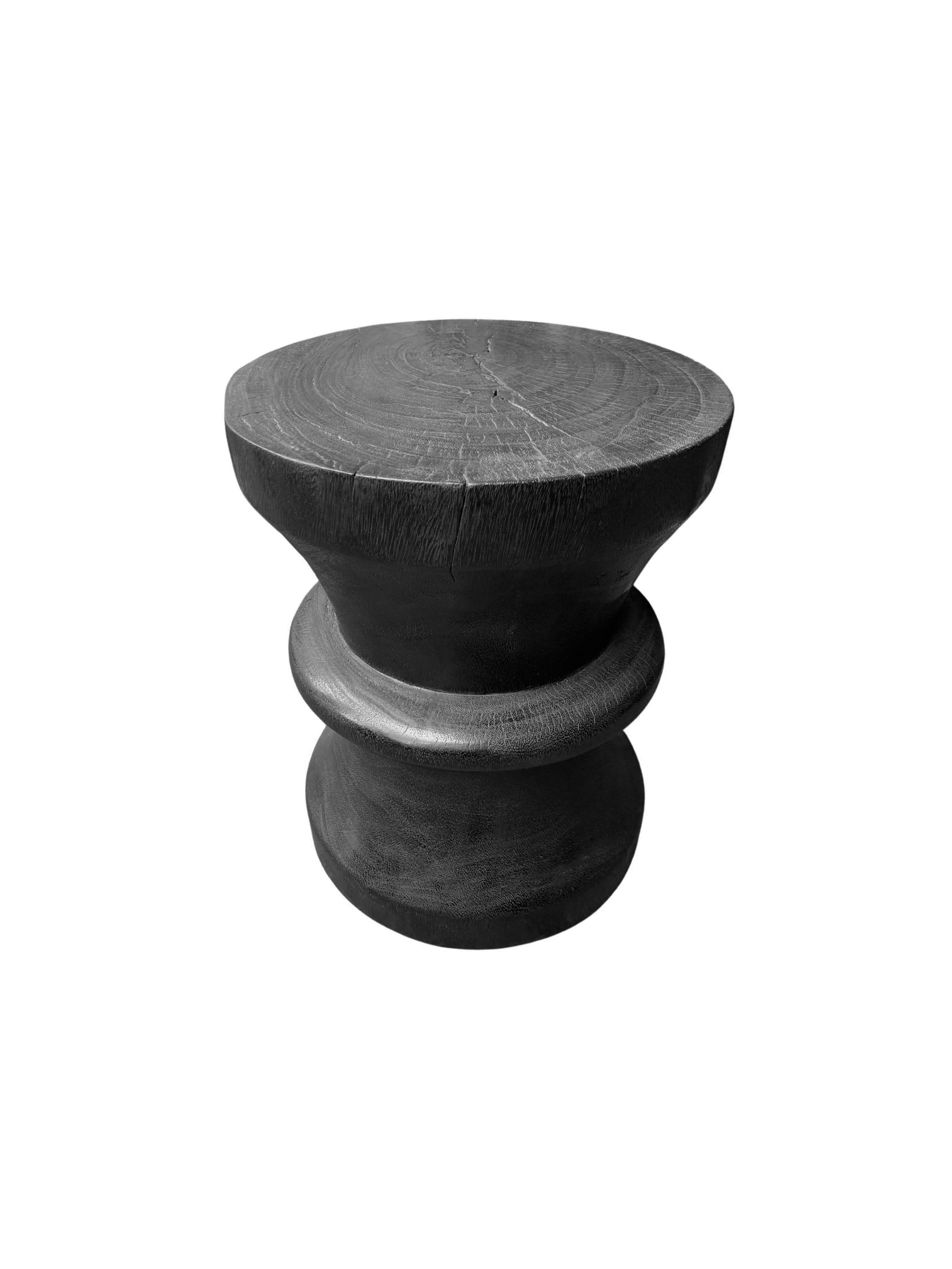 A wonderfully sculptural round side table. Its black pigment was achieved through a burning process creating both a wonderful colour and effect. Its neutral pigment and subtle wood texture makes it perfect for any space. A uniquely sculptural and