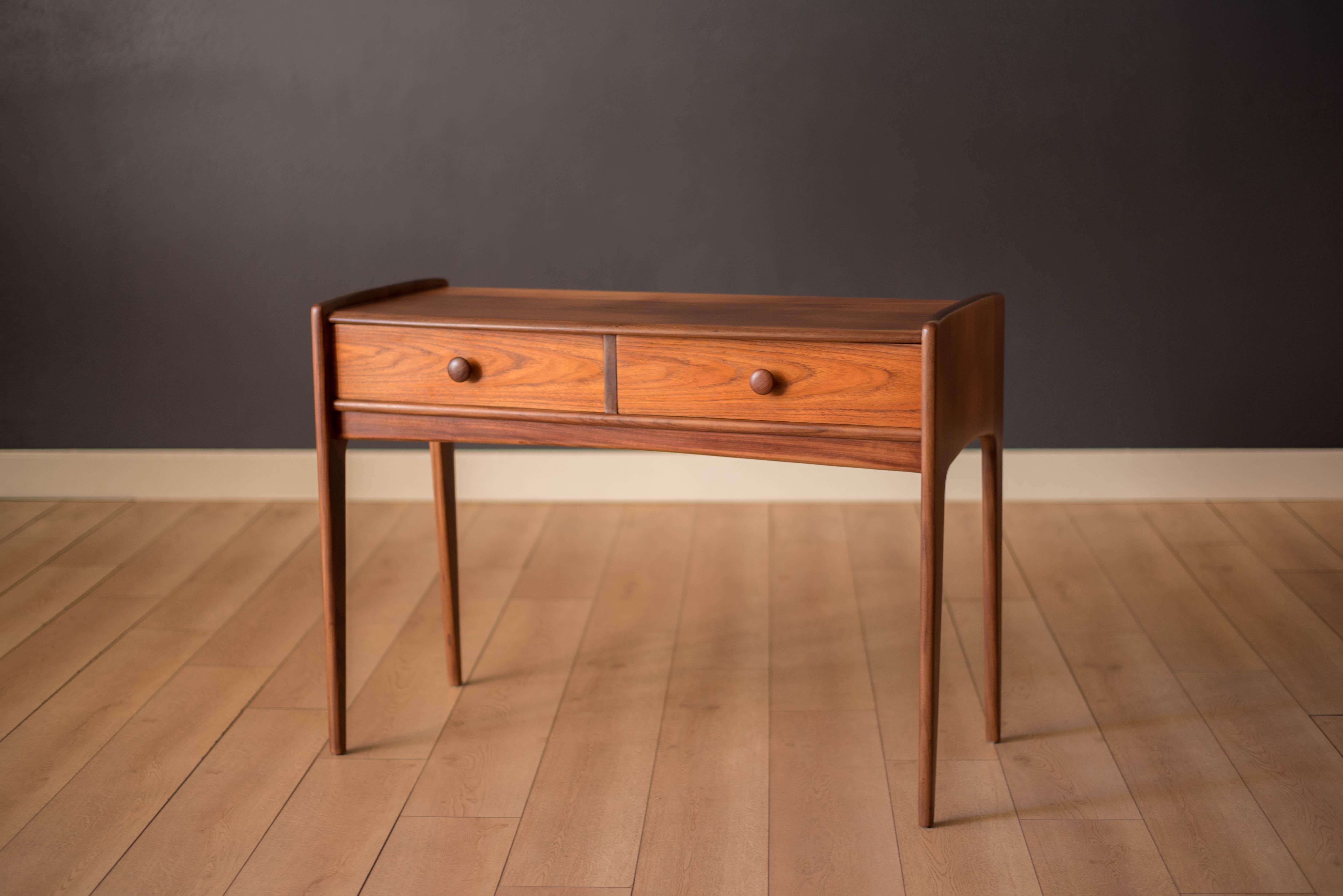 Vintage entryway console or sofa table designed by John Herbert for A. Younger Ltd, circa 1960s. Features a sculptural case crafted in solid planked teak afromasia. Includes two dovetailed drawers with round teak pulls. This versatile storage piece