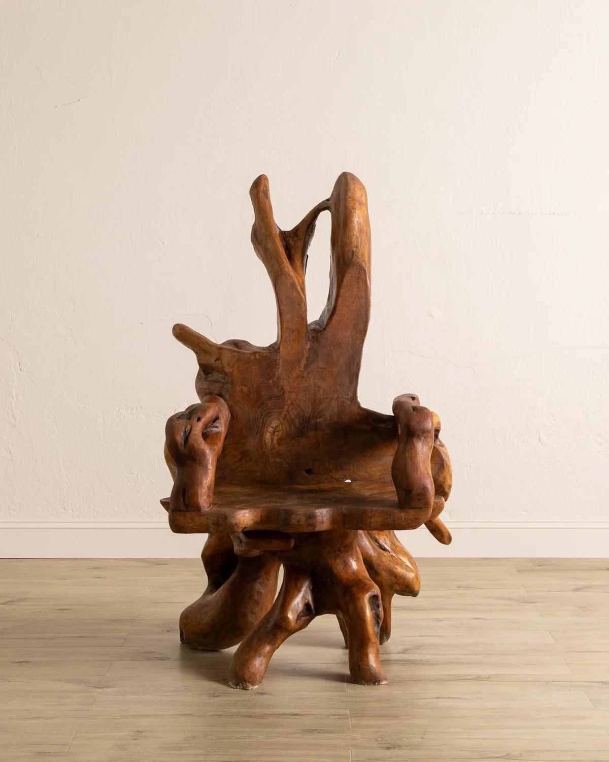 Fabriquée à partir d'une racine de teck massif, cette chaise sculpturale est une pièce d'apparat saisissante et unique qui respire l'art naturel. La forme organique met en valeur la beauté du teck, avec des accoudoirs et une large assise en dalle