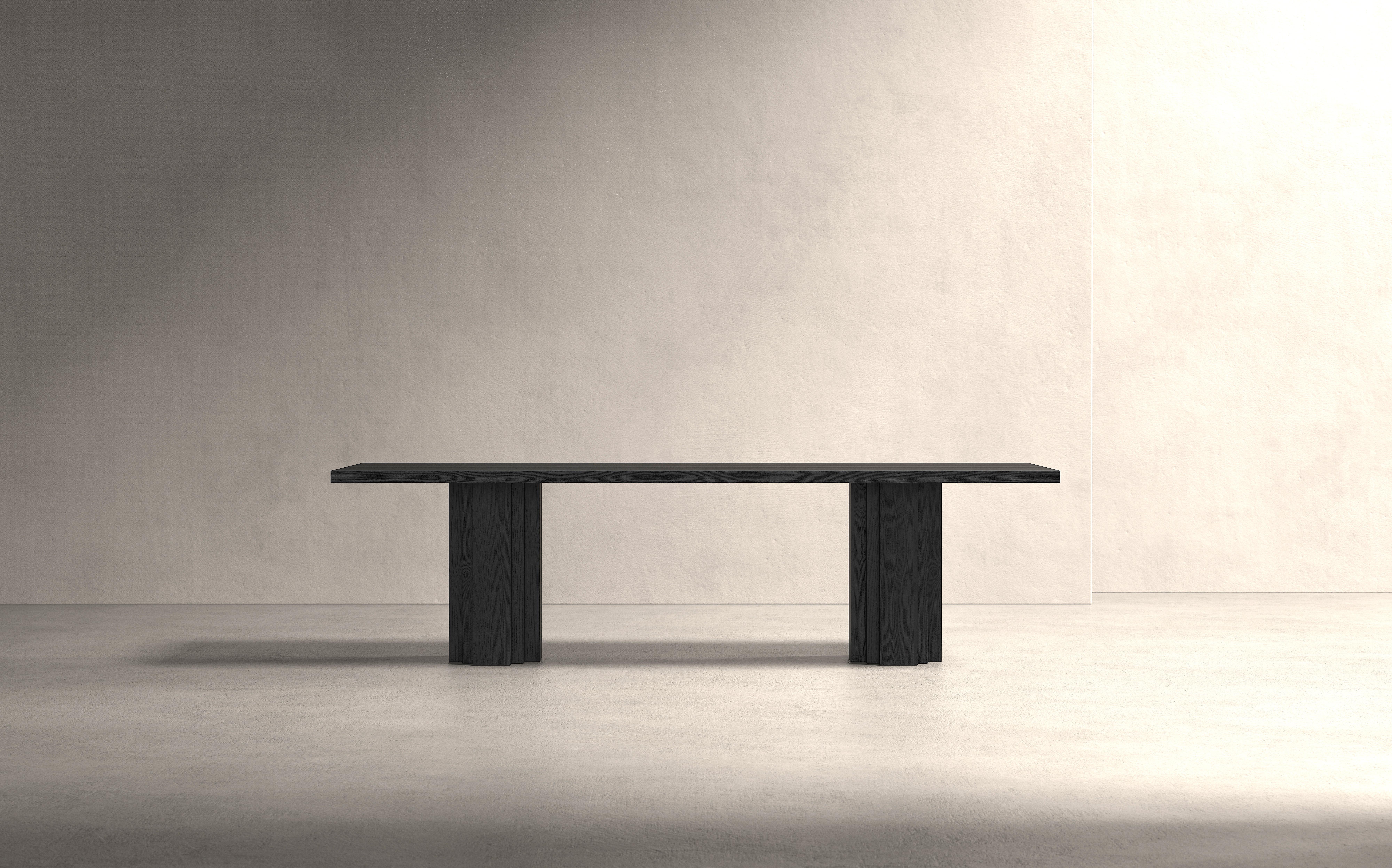 La table sculpturale Brut est inspirée par les styles architecturaux du Brutalisme et de l'École d'Amsterdam et est fabriquée en bois dur massif. Un banc assorti est disponible. La table est fabriquée sur mesure et entièrement