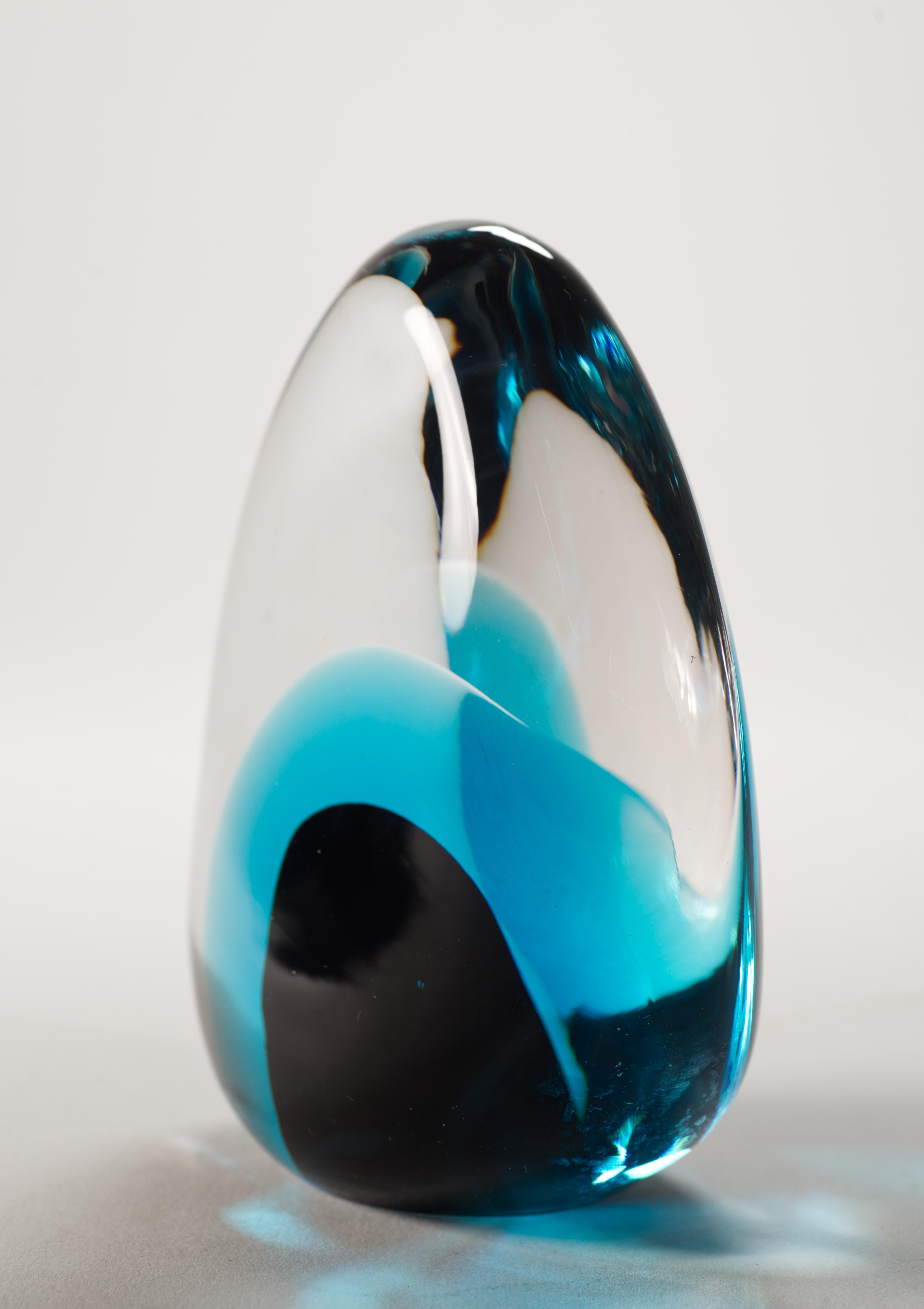 Sculptural vintage Murano glass paperweight features color blocked black and teal colored glass core, enclosed in clear glass in sommerso technique. The paperweight has flattened teardrop shape with organic, soft curves that are accentuated by the