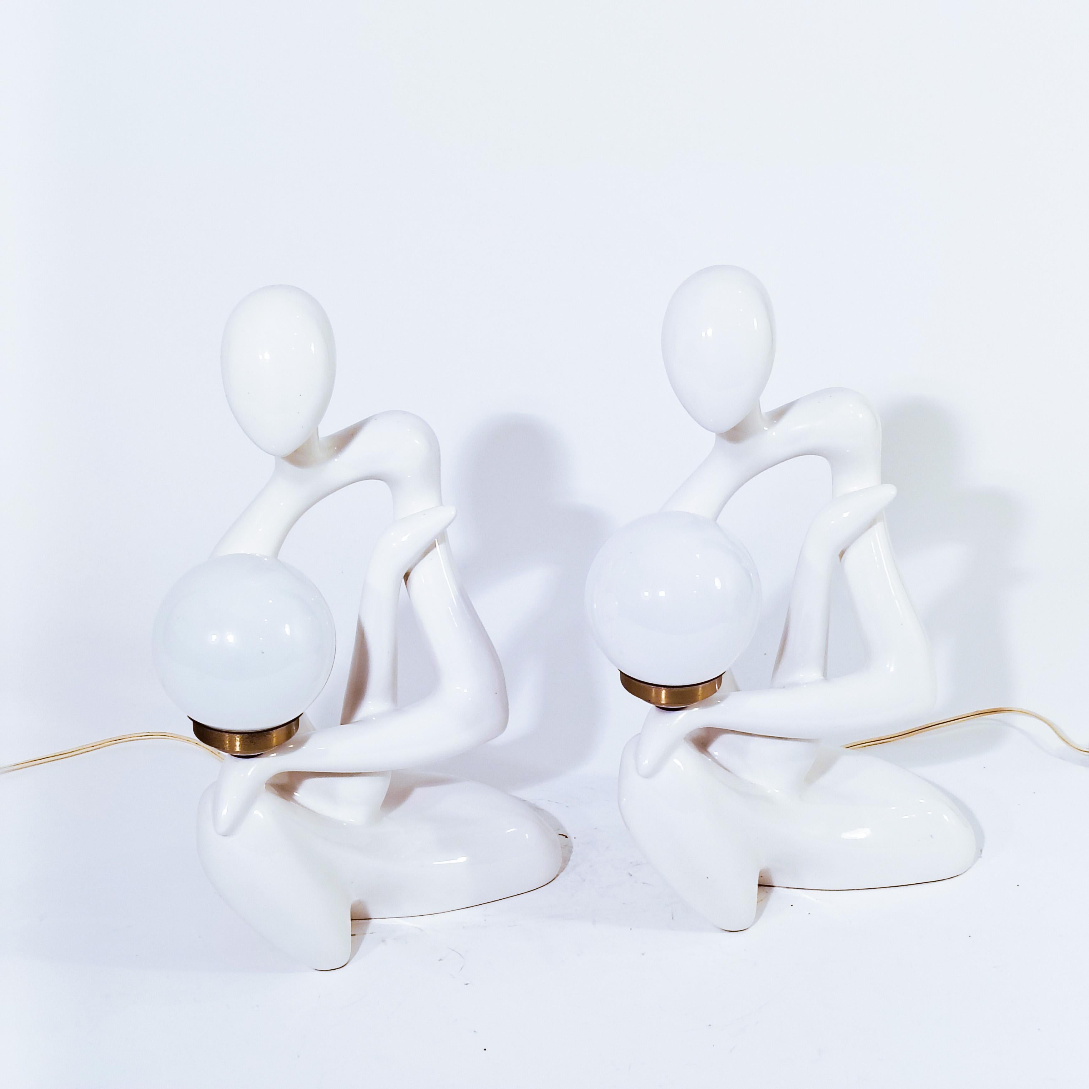 Lampes de table futuristes sculpturales en céramique, Espagne, années 1970, ensemble de 2. Toutes deux formées d'une silhouette humaine de style figuratif en céramique blanche, qui tient un support de lampe en laiton doré avec un diffuseur en verre