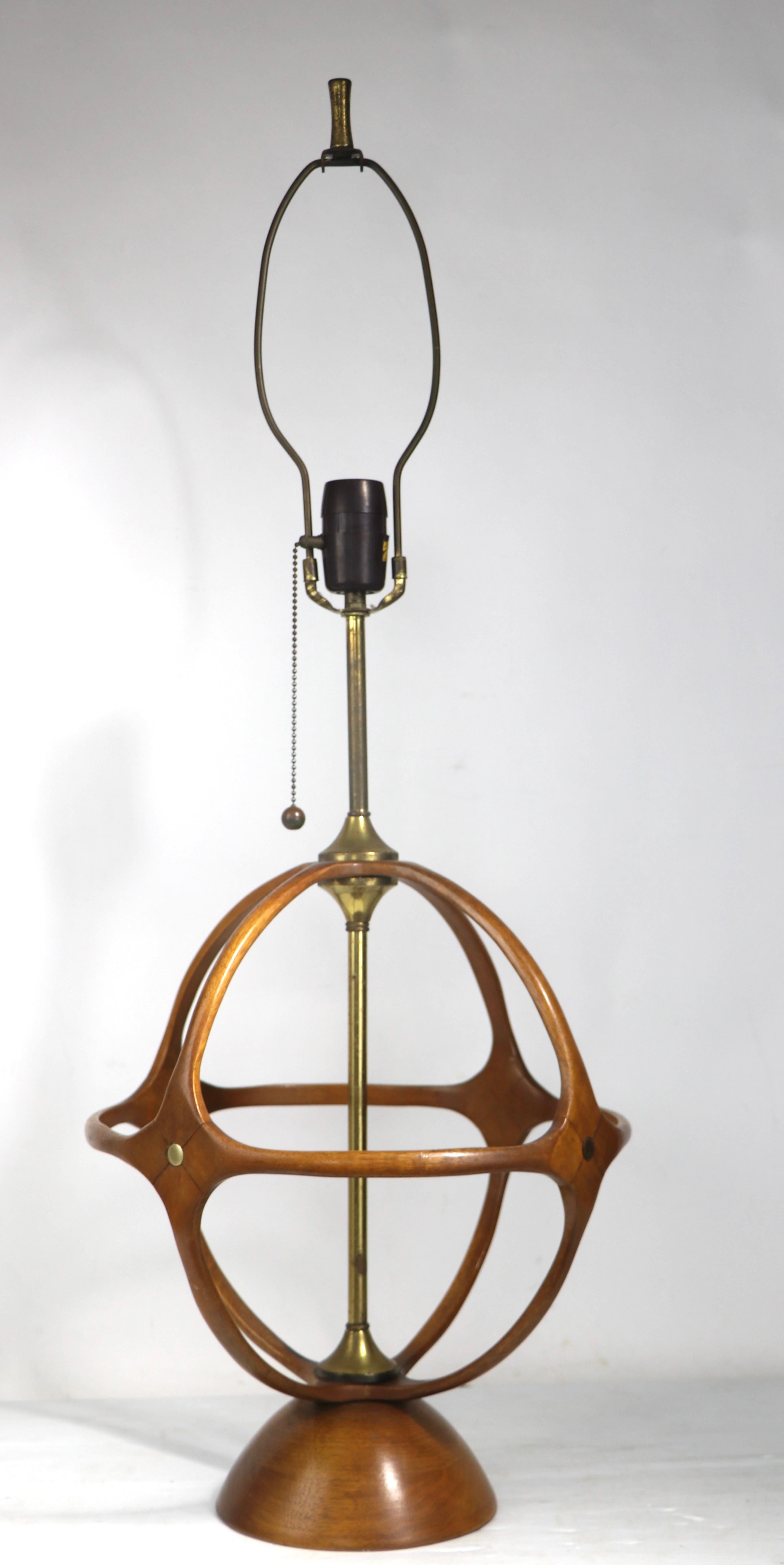 Wonderful architectural mid century table lamp by Modeline of California, in the style of Adrian Pearsall. The lamp features a ball, or globe form body of sculpted wood ( walnut ) with decorative brass highlights. This example is in excellent