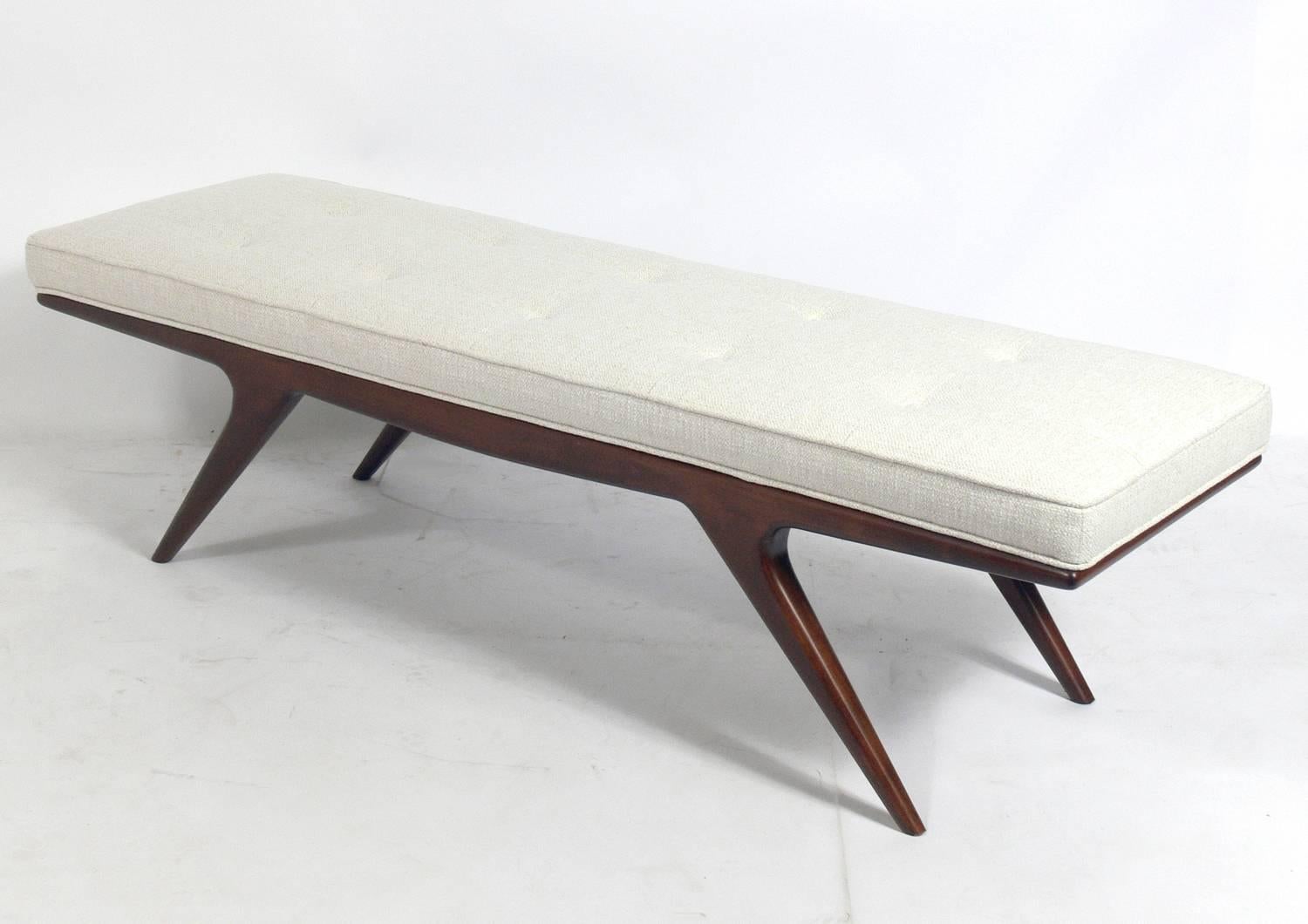 Sculptural splayed leg bench, circa 1960s. It has been refinished and reupholstered in an ivory color boucle fabric.