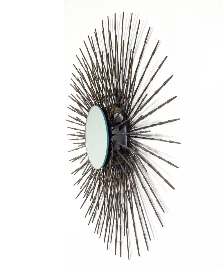 Sculptural sunburst nail mirror, American, circa 1960s. Handmade with welded patinated nails. Overall diameter is 32 inches, diameter of mirror is inches. Retains warm original patina.