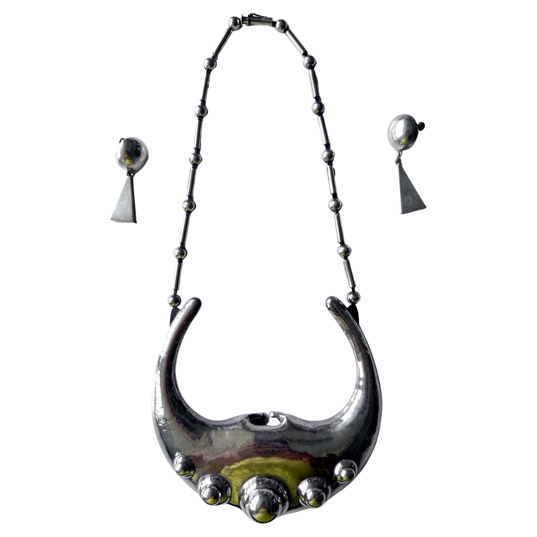 Une étonnante suite de bijoux en argent sterling au design audacieux de Graziella Laffi (1923-2009), Lima, Pérou, vers les années 1970. L'ensemble se compose d'un collier très sculptural avec un grand pendentif et d'une paire de boucles d'oreilles