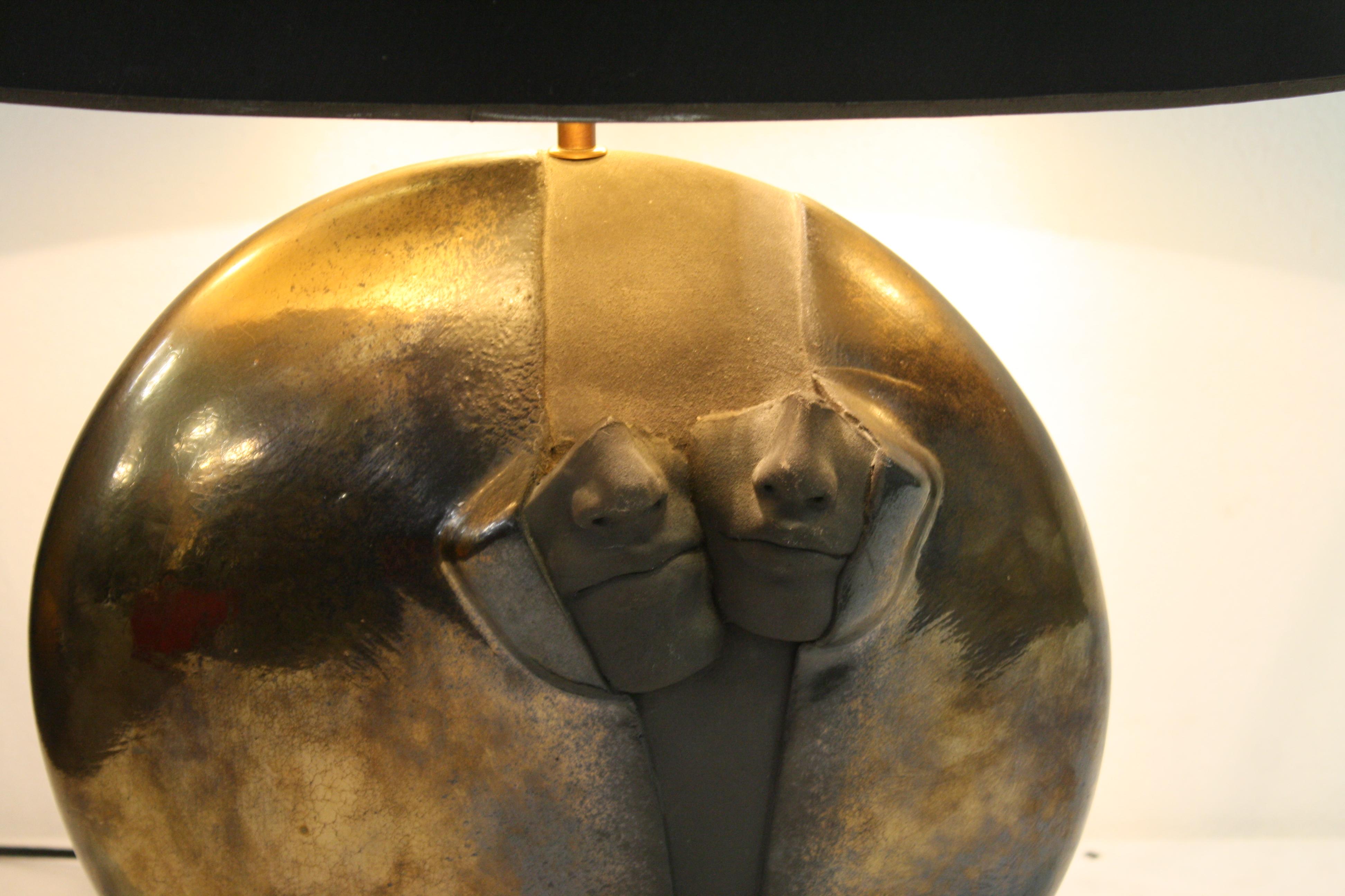 Beeindruckende skulpturale Tischlampe aus Stein.

Die Tischleuchte besteht aus einer Steinskulptur, die zwei teilweise aus dem Stein herausgebrochene Gesichter darstellt, die auf einem schwarzen Marmorsockel montiert sind.

Der Stein hat eine