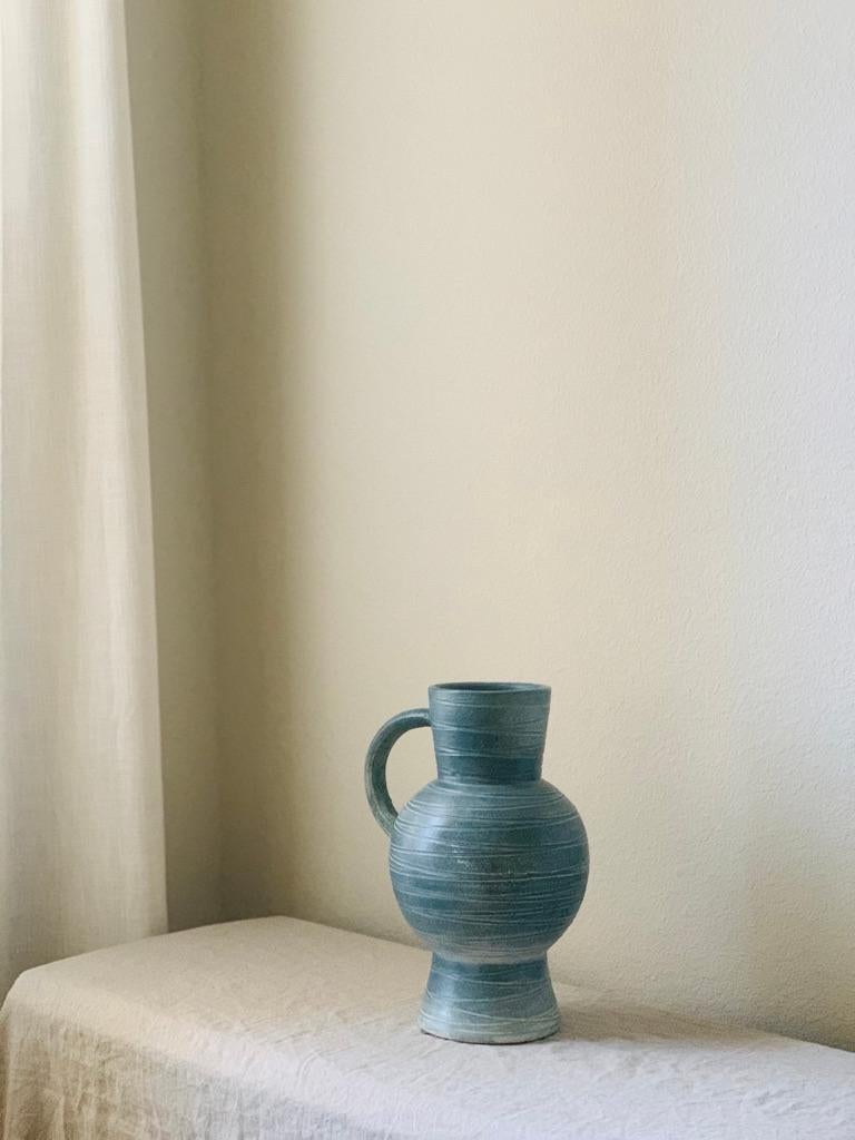 Handled stoneware pitcher. Defined by its sculptural silhouette, carved geometric lines on it's surface & unique glazing. In excellent vintage condition.