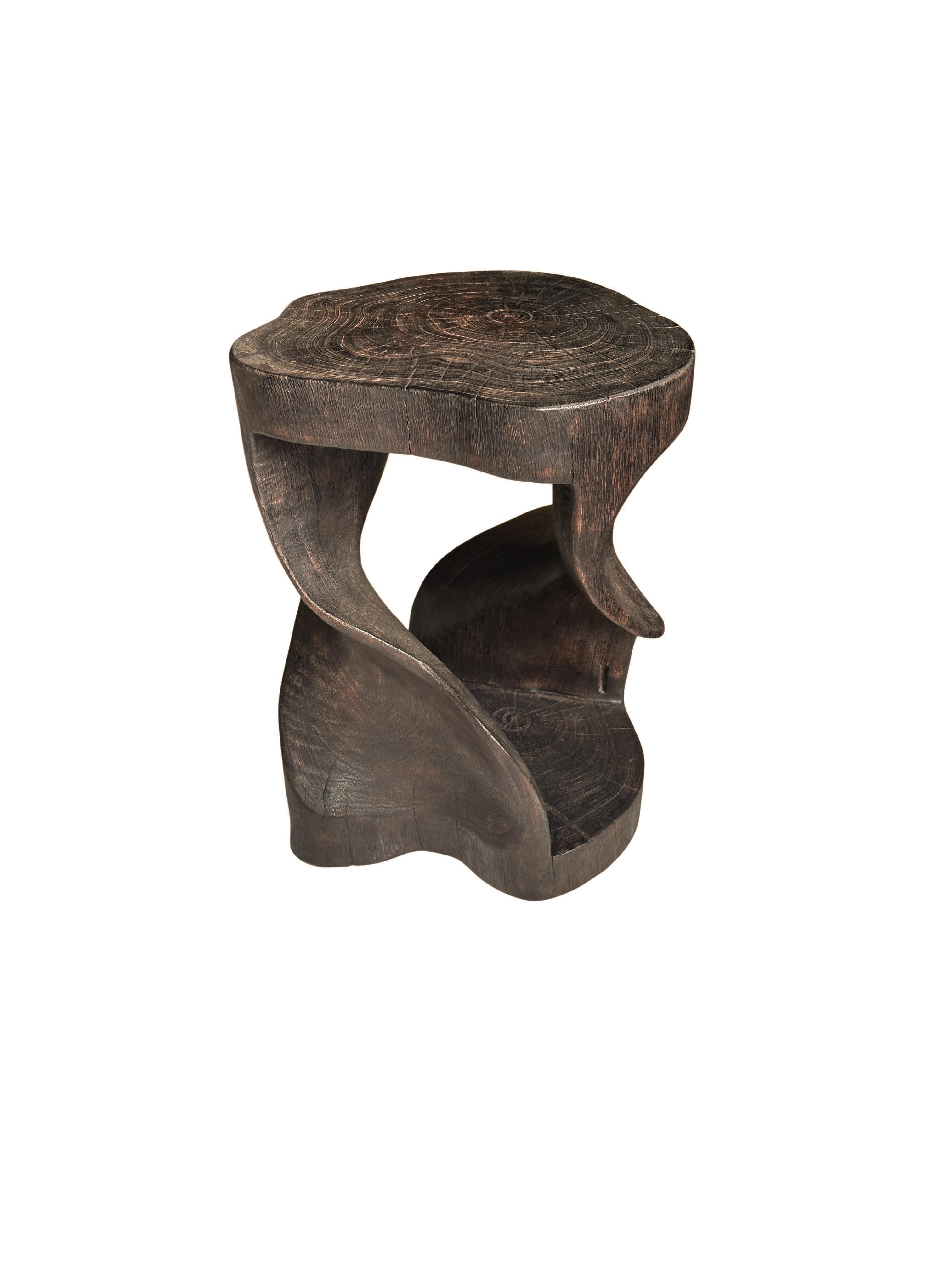 A wonderfully sculptural stool, with a mix of wood textures and shades. It features a spiral design, with an exposed core. A uniquely sculptural and versatile piece, this chair was crafted from a single block of mango wood and has a smooth texture.