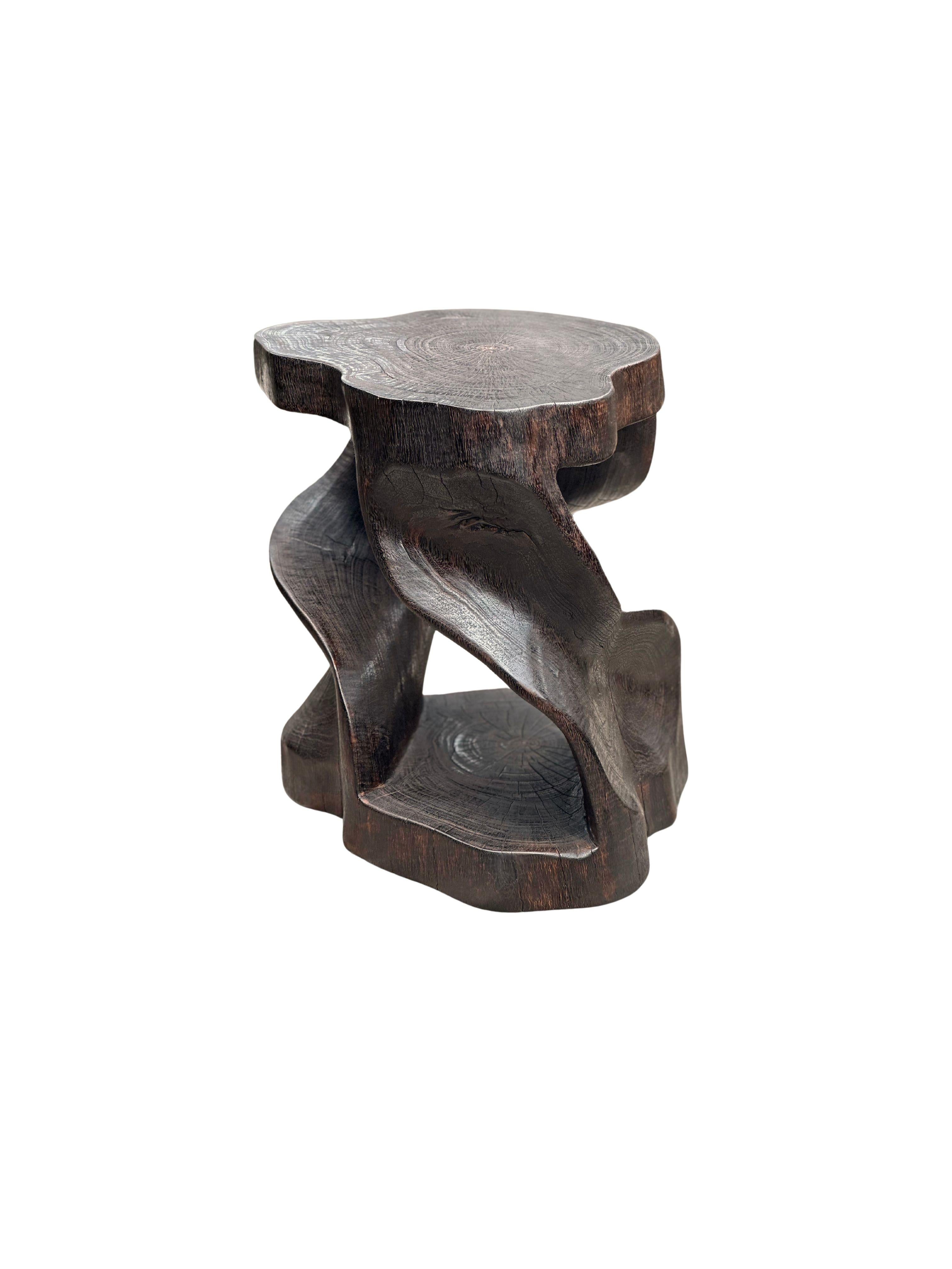 A wonderfully sculptural stool, with a mix of wood textures and shades. It features a spiral design, with an exposed core. A uniquely sculptural and versatile piece, this chair was crafted from a single block of mango wood and has a smooth texture.