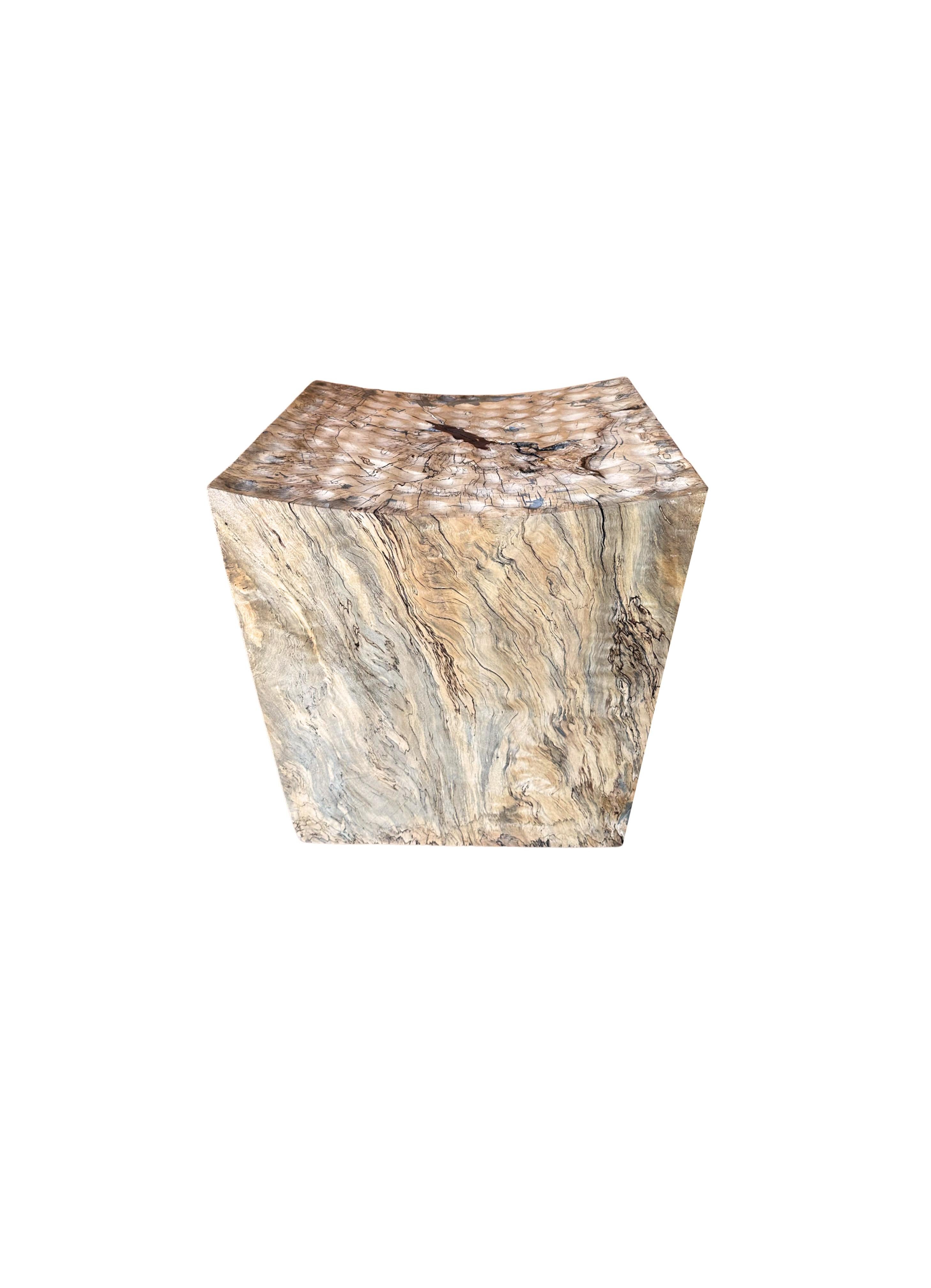 A wonderfully sculptural stool with mix of wood textures and shades. A uniquely sculptural and versatile piece, this chair was crafted from a single block of tamarind wood. This wood features elegant markings that resemble a block of marble.