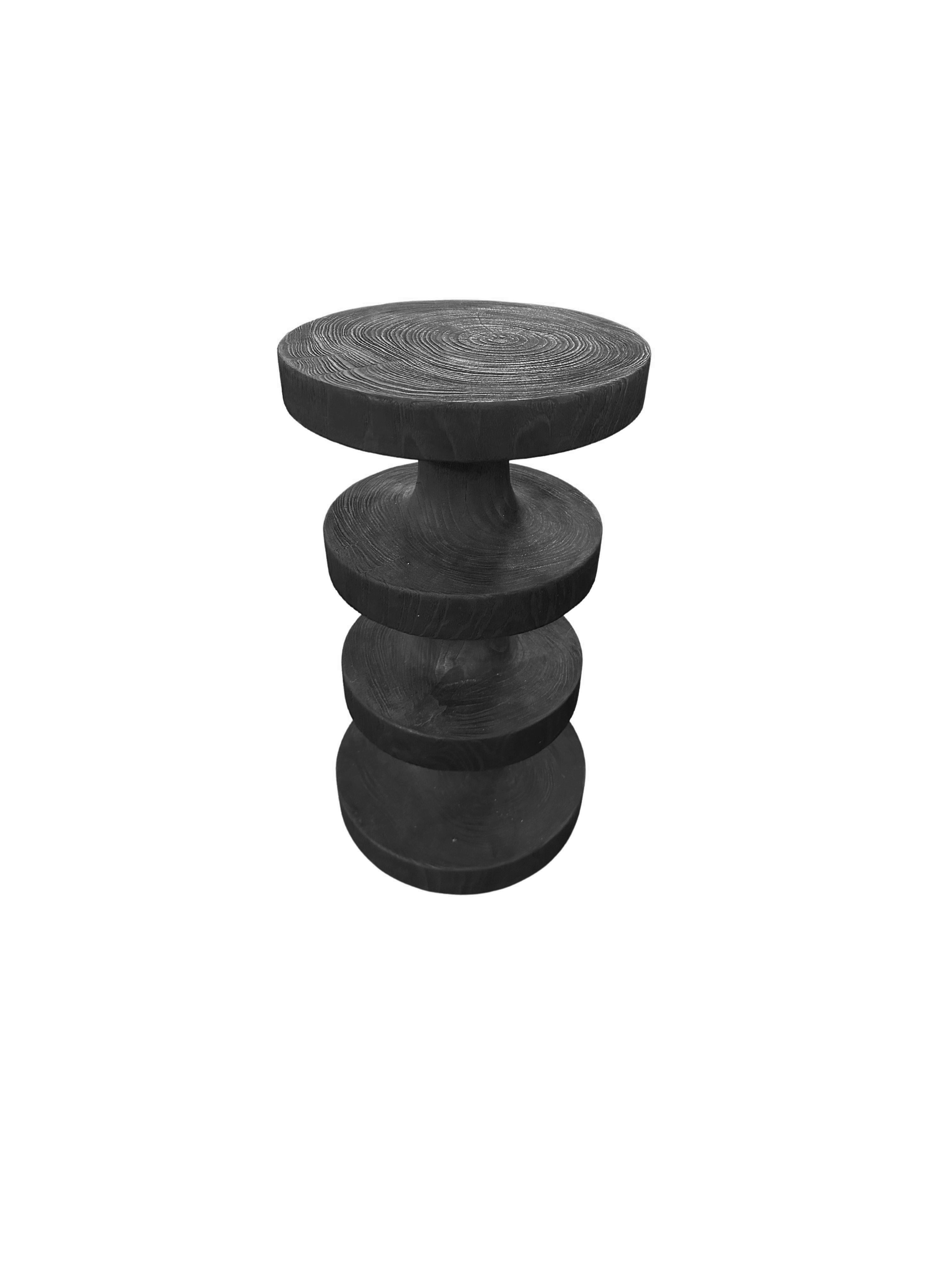 A wonderfully sculptural stool with mix of wood textures and shades. A uniquely sculptural and versatile piece, this stool was crafted from a single block of teak wood and has a smooth texture. Meticulously carved, sanded and smoothed to the perfect