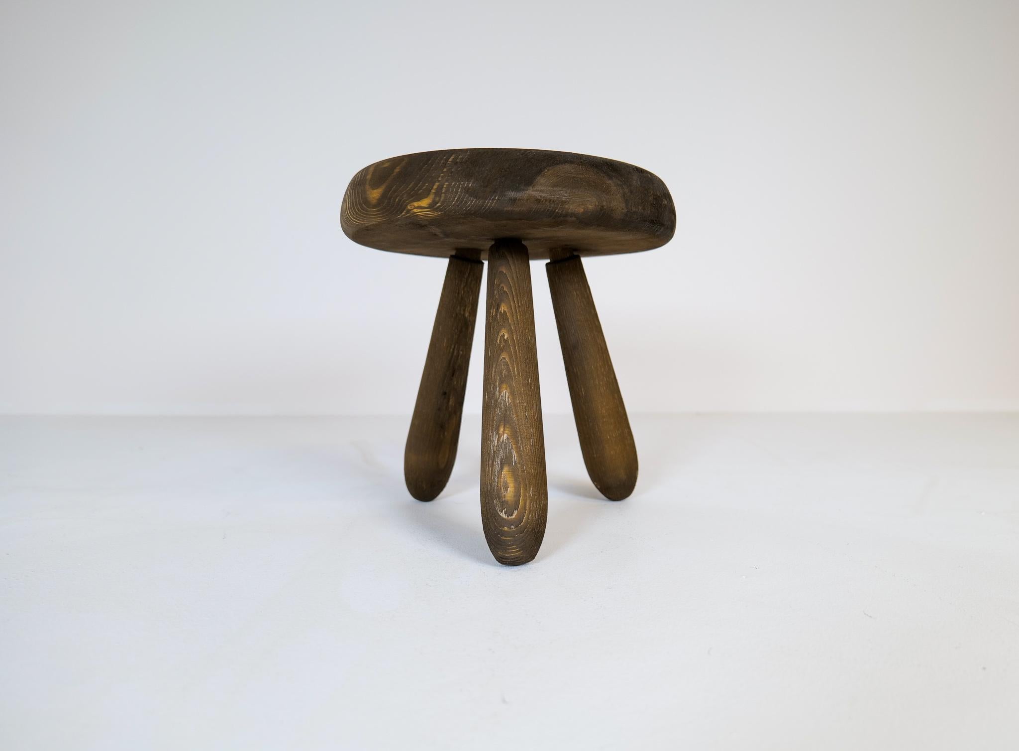 A small stool in stained solid pine with rare complexity in the different colors of the wood.
This stool is a good example of the good craftsmanship and minimalistic stile to come in Scandinavian furniture. 

 Very good original condition with a