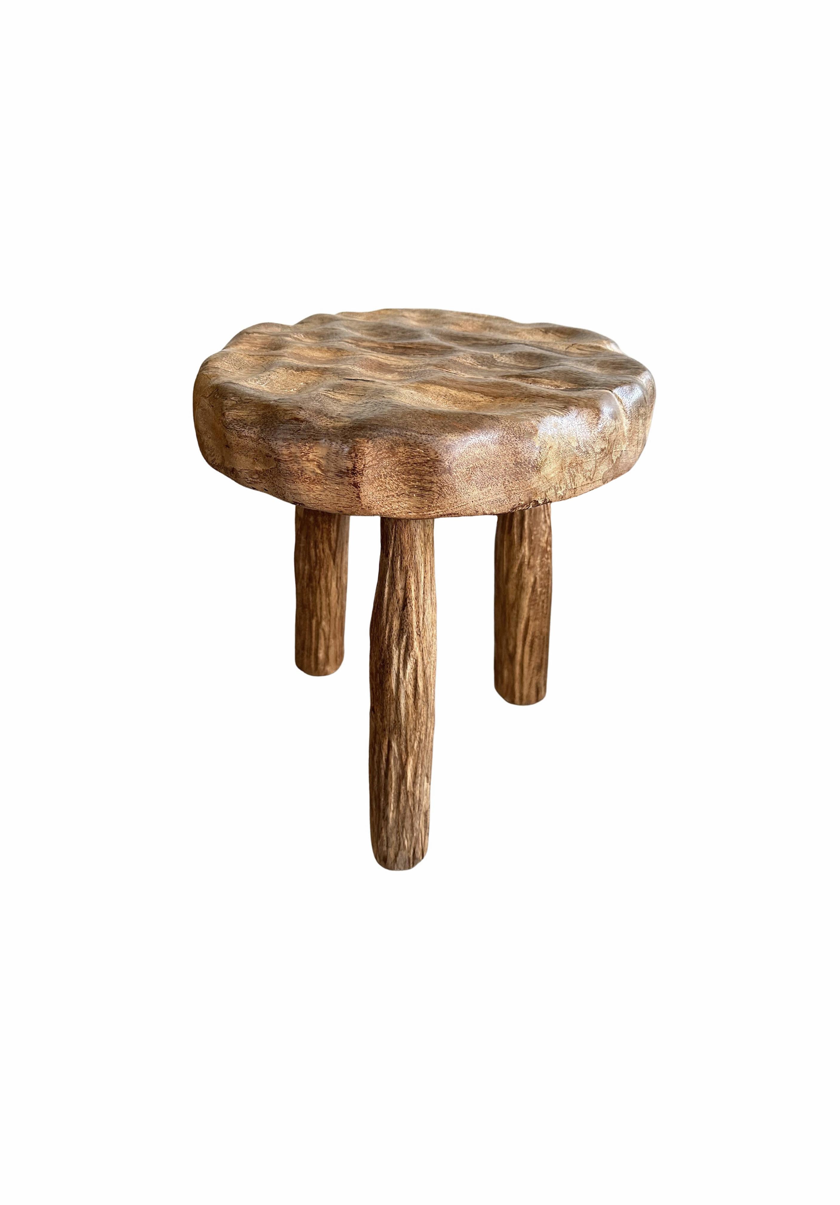 An elegantly rounded, sculptural stool crafted from mango wood. Unique to this stool is the hand-hewn detailing on all sides providing a wonderful contrast of textures.