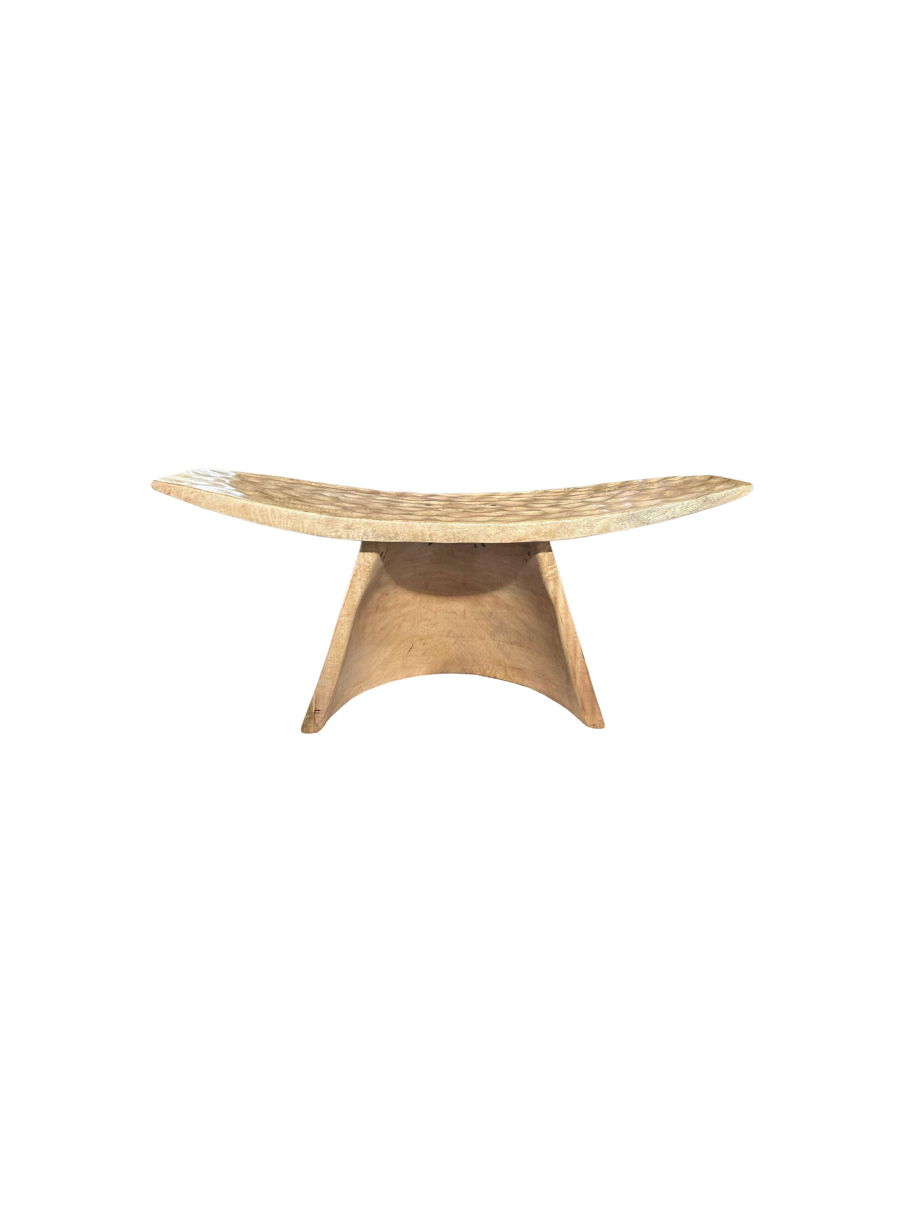A wonderfully sculptural stool with a curved seat and hand hewn detailing. The stool's neutral pigment and subtle wood texture makes it perfect for any space. A uniquely sculptural and versatile piece. This stool was crafted from mango wood.

 