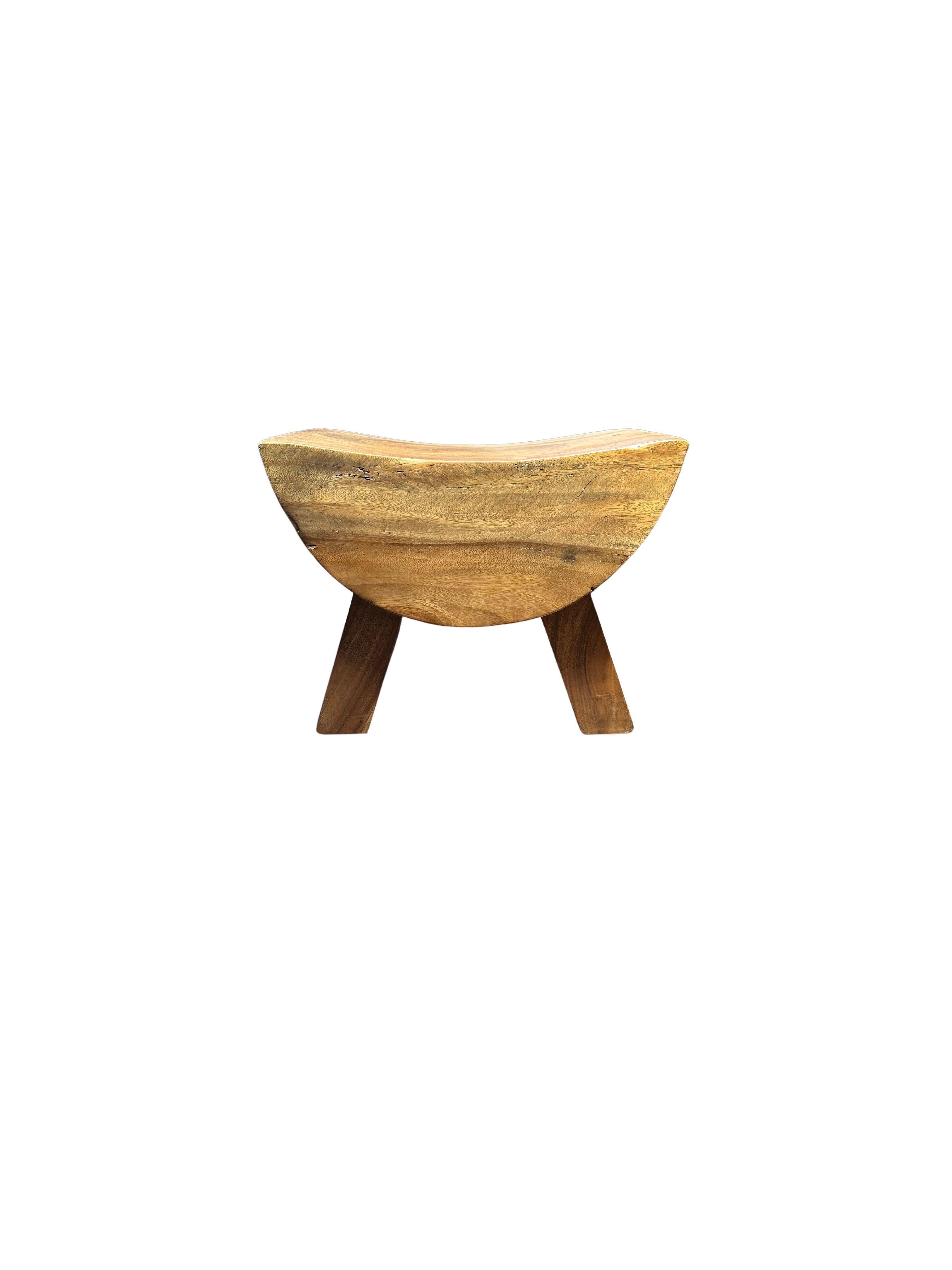 Un taburete maravillosamente escultural con asiento curvado. El pigmento neutro del taburete y su sutil textura de madera lo hacen perfecto para cualquier espacio. Una pieza única, escultural y versátil. Este taburete se fabricó con madera de Suar.