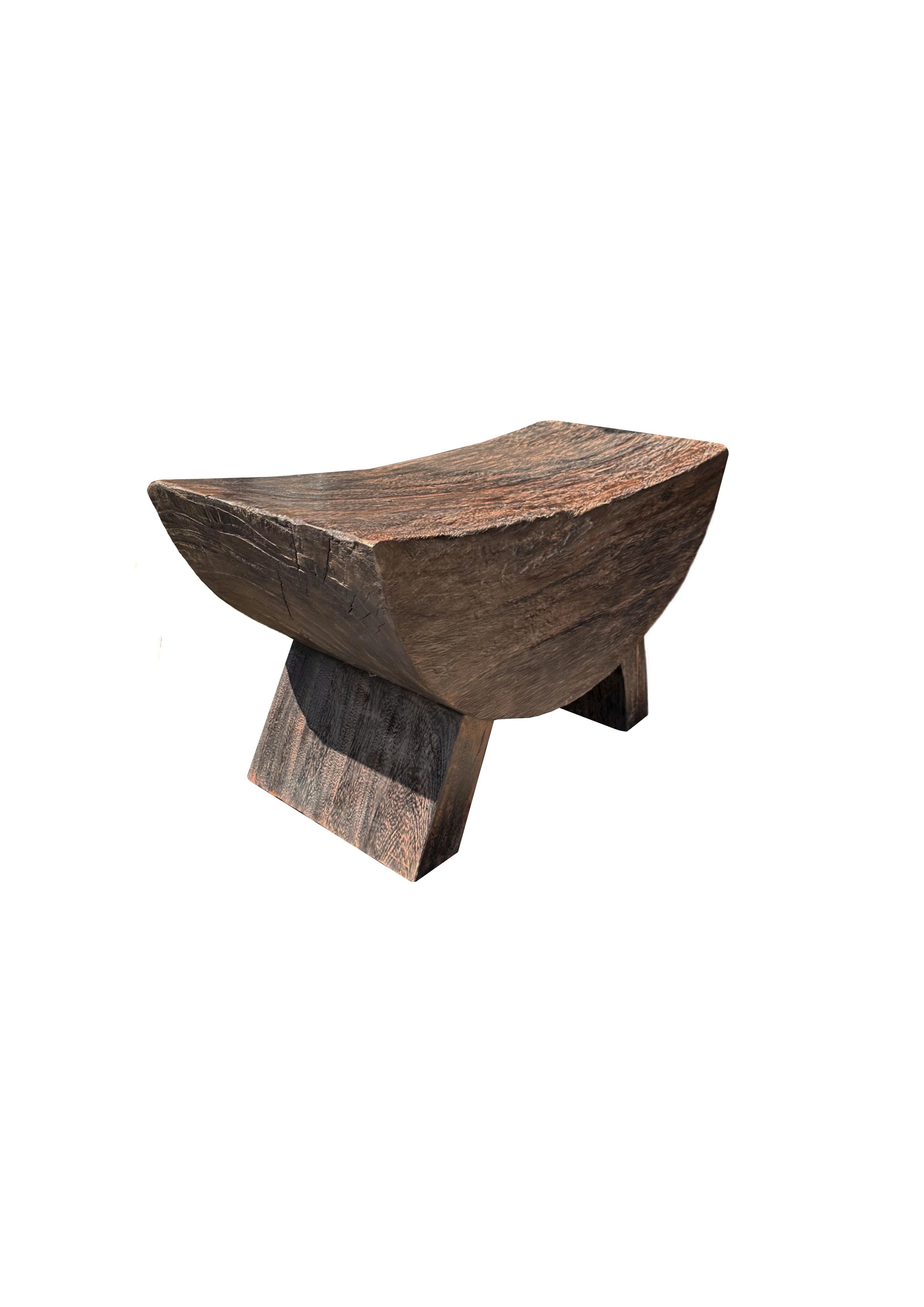 A wonderfully sculptural stool with a curved seat. The stool's neutral pigment and subtle wood texture makes it perfect for any space. A uniquely sculptural and versatile piece. This stool was crafted from Suar wood.

 