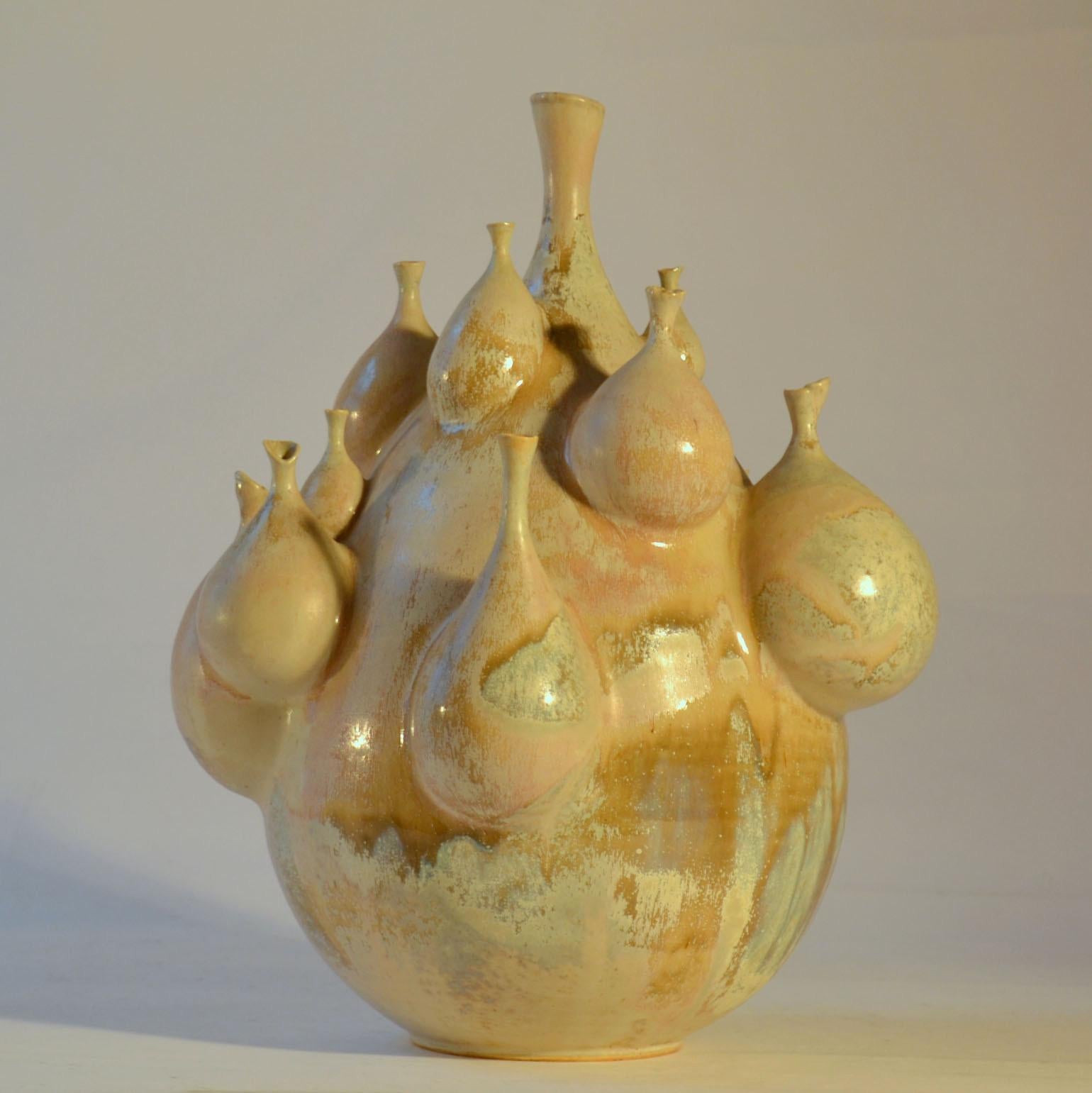 Unique Studio Pottery vase with many small vases attached to the main body is sculpted by M Fisher, Germany. The glaze colors vary from cream to light pink and blue to mustard.