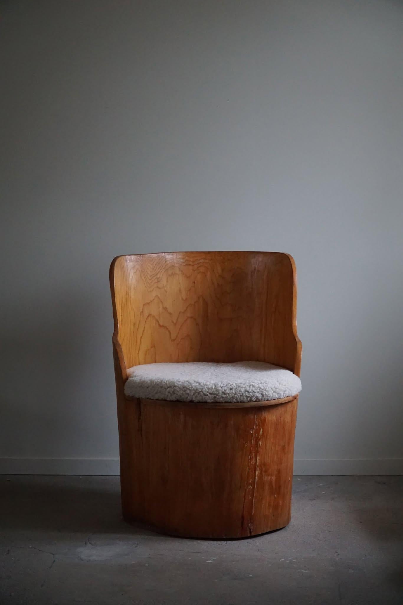 Sculptural rustic stump chair made in solid pine. Hand carved by a Swedish cabinetmaker in the 1960s. Beautiful wood grains in this vintage piece, a truly authentic brutalist piece. Seat cushion reupholstered in a quality shearling lambswool, adding