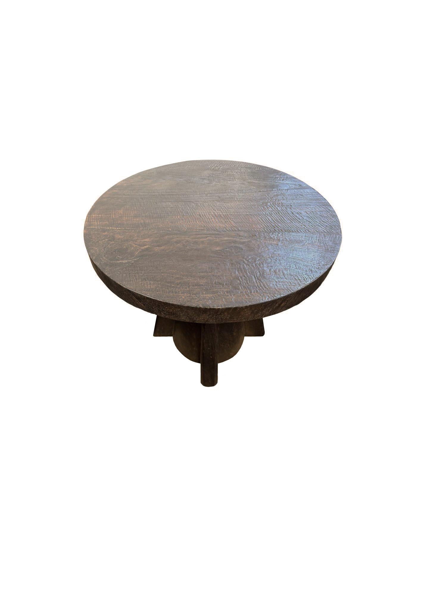 Une table d'appoint ronde merveilleusement sculpturale. Fabriqué en bois de suar massif avec des textures et des nuances de bois. Le plateau de la table a été fabriqué à partir d'un seul bloc de bois soutenu par des pieds angulaires. Un objet