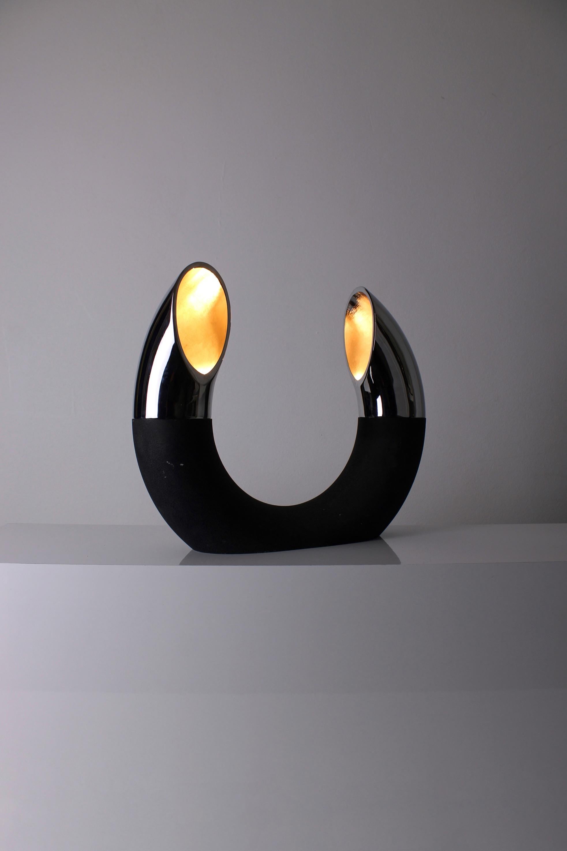 Very sculptural-shaped table lamp. Produced by Fratelli Martini (the Martini Brothers) in Italy. Some designers that worked for Flli. Martini were E. Bosi, Bertotti and Martini himself. This table lamp has a black lacquered cast iron U-shaped