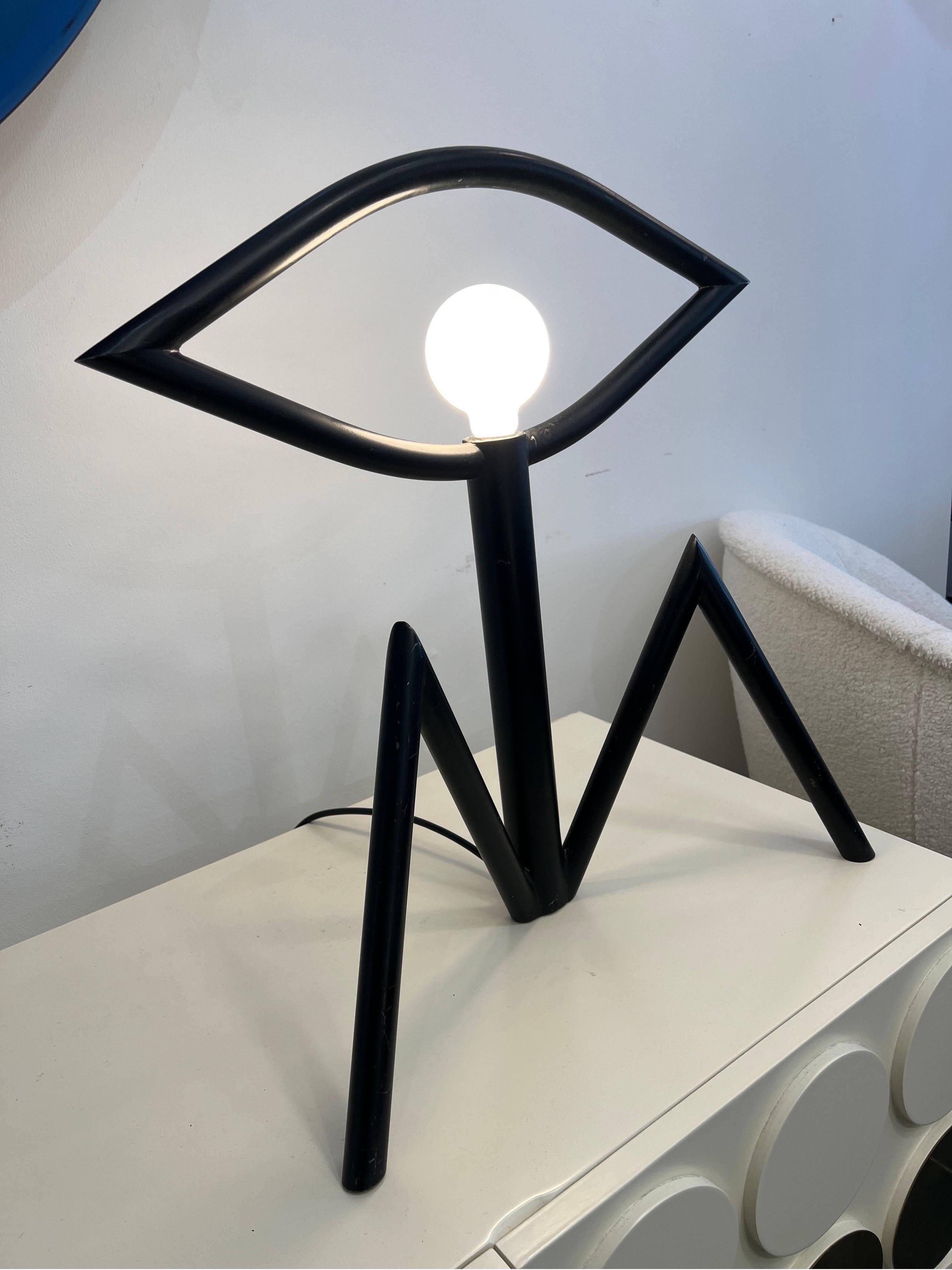 A sculptural table lamp in black powder coated steel depicting an abstract sitting figure by Stephen Bam for Maxray Japan.

Dimensions: D:18cm W:49cm H:54cm